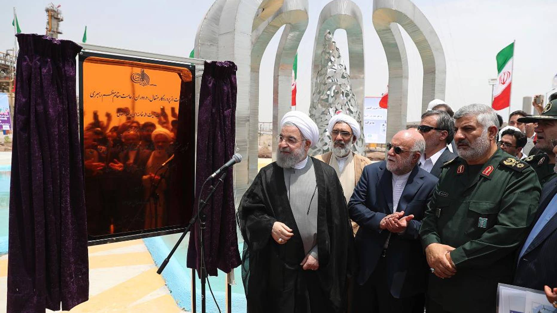 In this photo released by an official website of the office of the Iranian Presidency Sunday, April 30, 2017, Iranian President Hassan Rouhani, center left, inaugurates a new refinery that produces some 12 million liters (3.17 million gallons) of gas in its first phase, in Bandar Abbas, some 750 miles (1,205 kilometers) south of Tehran, Iran. Iran's official IRNA news agency is saying the country has become self-sufficient in producing the amount of gas the country requires on a daily basis. (Iranian Presidency Office via AP)