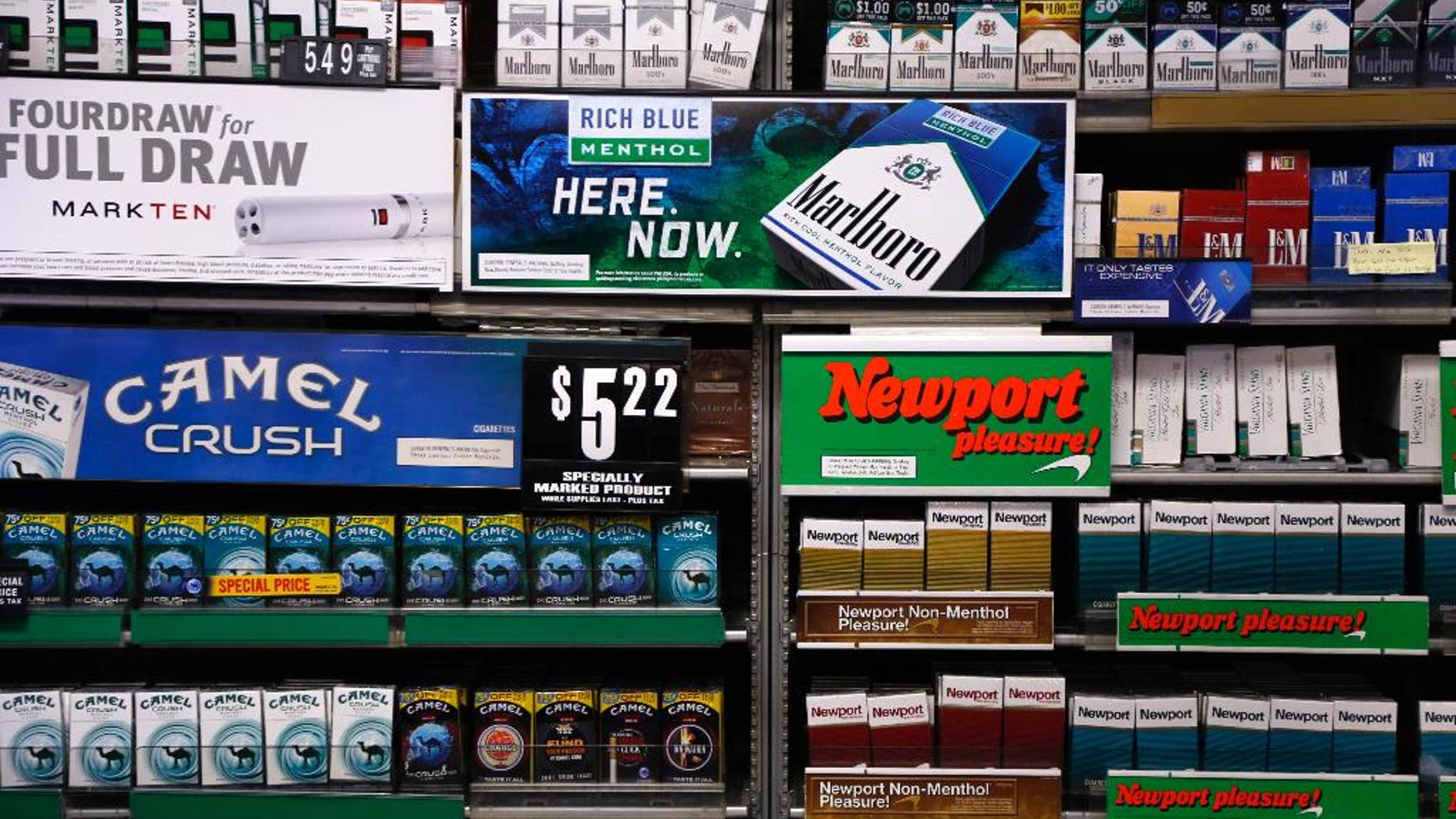FILE - In this Friday, July 17, 2015 file photo, Camel and Newport cigarettes, both Reynolds American brands, are on display at a Smoker Friendly shop in Pittsburgh. British American Tobacco offered Friday, Oct. 21 2016 to buy Reynolds American Inc. in a $47 billion cash-and-stock deal that would create the world’s largest publicly traded tobacco company and bring together brands like Camel, Dunhill, and Newport. The logic of the deal, analysts say, is to make up for a decline in the number of smokers in their home markets of the U.S. and Britain as they look to developing markets and new products, such as electronic cigarettes. (AP Photo/Gene J. Puskar, file)