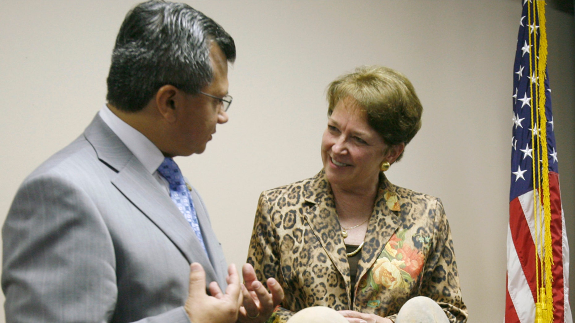 FILE - In this Sept. 23, 2008 file photo, U.S. ambassador to Ecuador Heather Hodges, right, speaks with Juan Carlos Toledo, consul general of the Ecuadorian consulate in Miami, by a display of pre-Columbian artifacts after a news conference at the Federal Bureau of Investigation Miami Field Office in North Miami Beach, Fla. Ecuador's government, on Tuesday April 5, 2011, has asked U.S. ambassador Hodges to leave in flap over cables divulged by WikiLleaks. (AP Photo/Wilfredo Lee, File)
