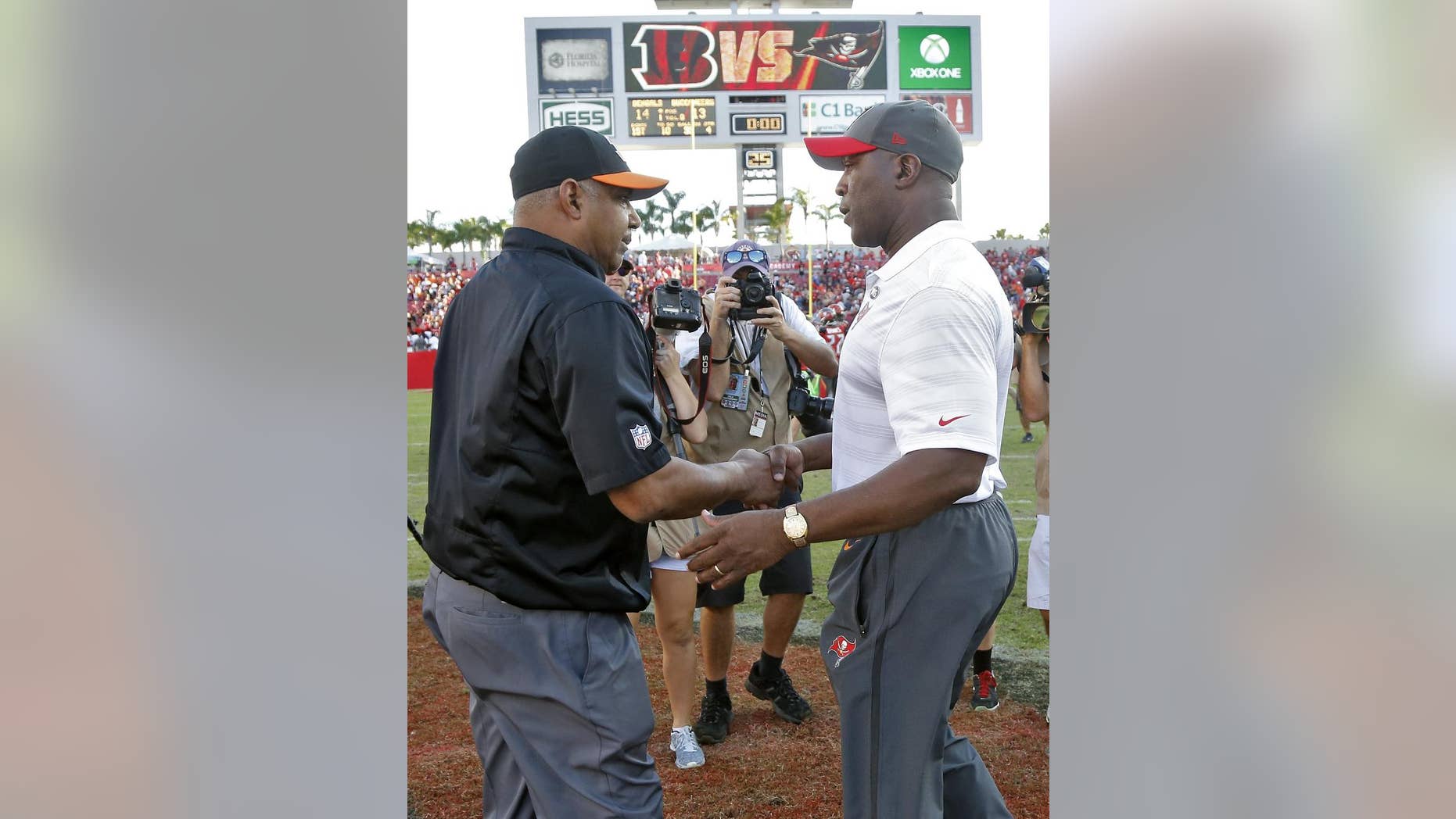 Cincinnati Bengals head coach Marvin Lewis, left, shakes hands with Tampa Bay Buccaneers head coach Lovie Smith after the Bengals defeated the Buccaneers 14-13 during an NFL football game Sunday, Nov. 30, 2014, in Tampa, Fla. (AP Photo/Brian Blanco)