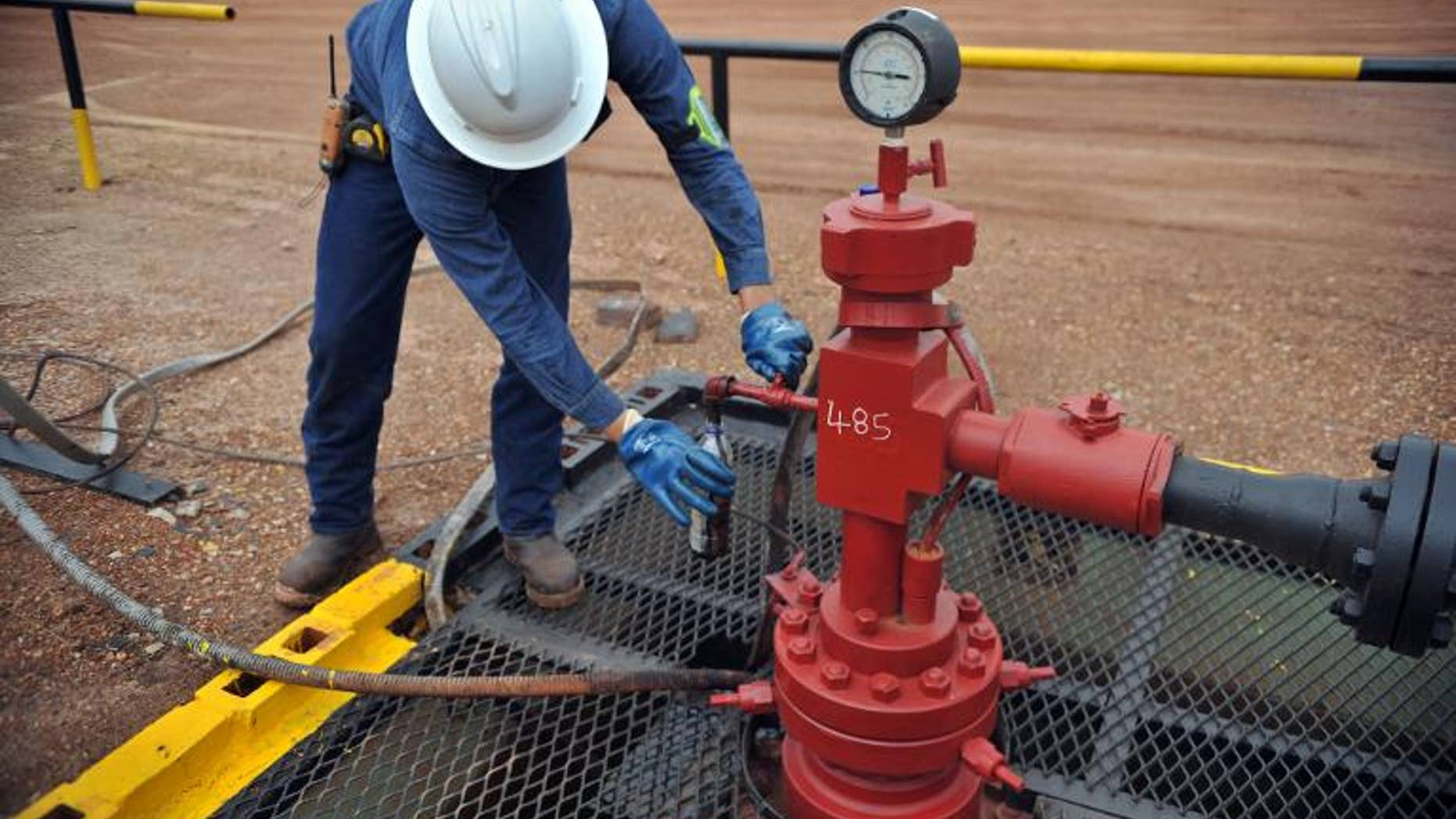 An engineer of Canadian oil company Pacific Rubiales takes a sample of heavy crude oil in Colombia's main oilfield Rubiales, on August 27, 2013