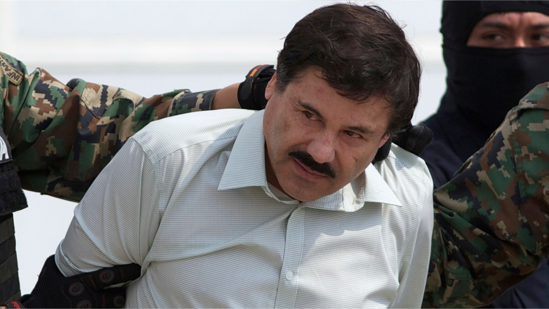 FILE - This Feb. 22, 2014 file photo shows Joaquin "El Chapo" Guzman, the head of Mexicoâs Sinaloa Cartel, being escorted to a helicopter in Mexico City following his capture overnight in the beach resort town of Mazatlan. A judge in Mexico has issued a second arrest warrant to detain escaped drug lord Joaquin "El Chapo" Guzman based on an extradition request from the United States. The federal prosecutorsâ office said Wednesday, Sept. 23, 2015 the new warrant is for U.S. charges of organized crime, money laundering drug trafficking, homicide and others. Guzman escaped on July 11, 2015 through a tunnel from Mexico's highest-security prison. (AP Photo/Eduardo Verdugo, File)