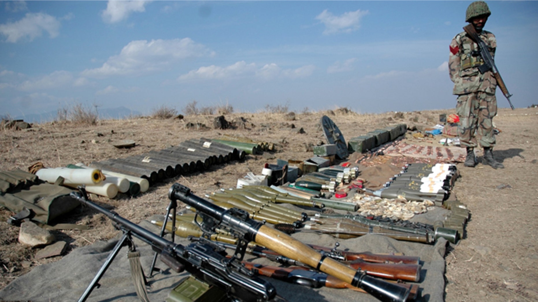 Pakistan army soldier stands next to ammunition seized from militants in Wana of Pakistani tribal region of Waziristan.