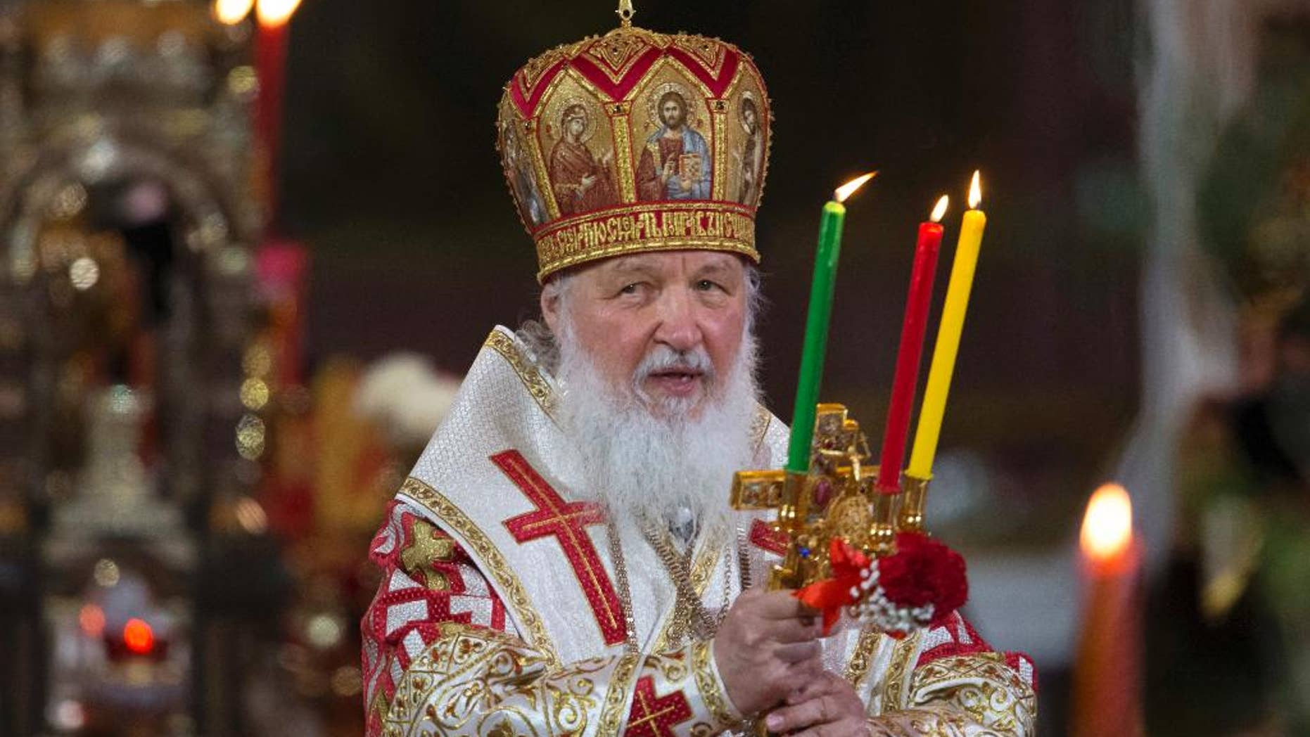 FILE - In this file photo dated Sunday, May 1, 2016, Russian Orthodox Patriarch Kirill holds candles during the Easter service in the Christ the Savior Cathedral in Moscow, Russia. The head of Russia's Orthodox Church, Patriarch Kirill begins a four-day visit to Britain, on upcoming Saturday Oct. 15, 2016, that includes an audience with Britain's Queen Elizabeth II. (AP Photo/Alexander Zemlianichenko, FILE )