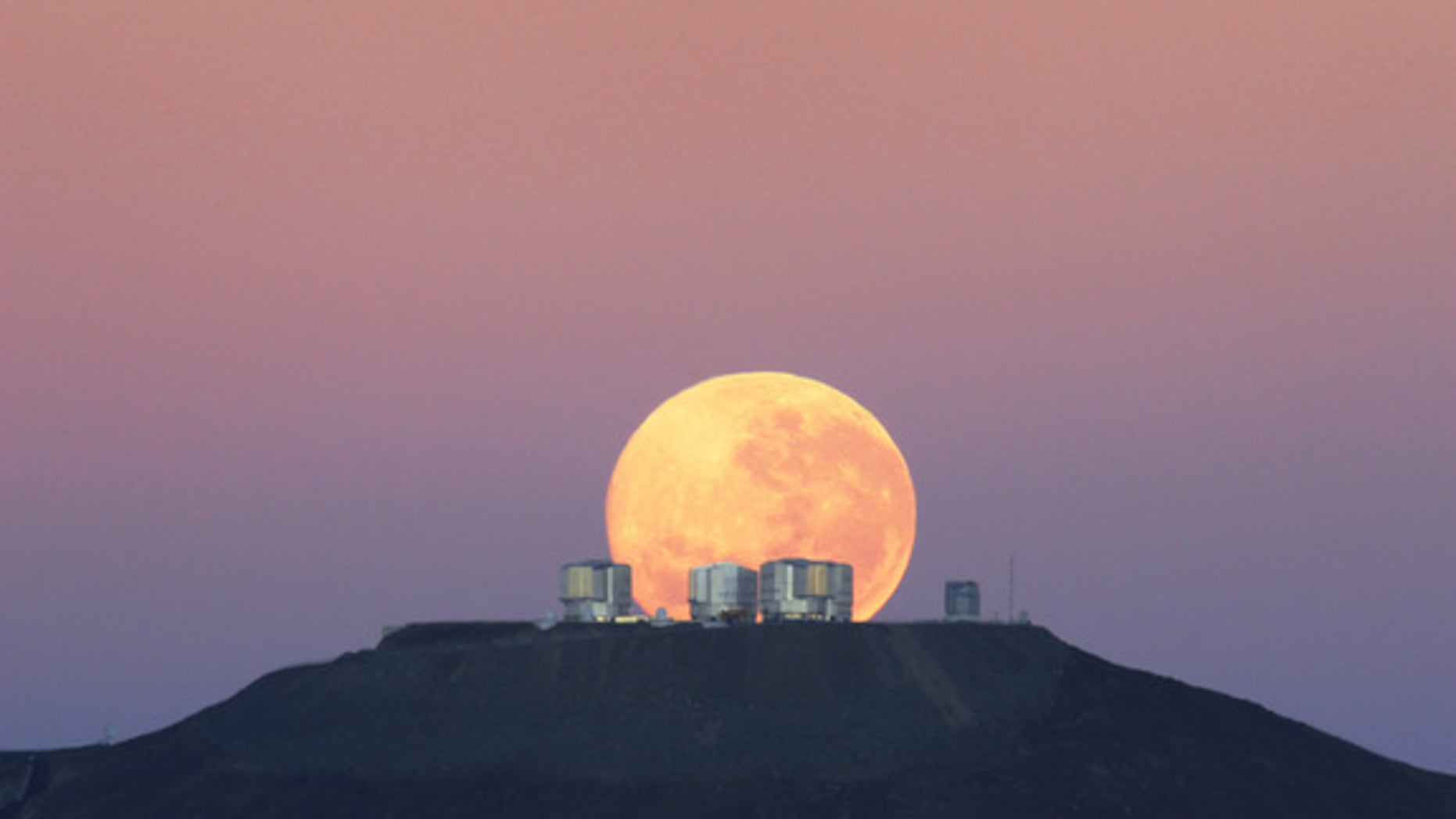 The dazzling full moon sets behind the Very Large Telescope in Chile's Atacama Desert in this photo released June 7, 2010 by the European Southern Observatory. The moon appears larger than normal due to an optical illusion of perspective.