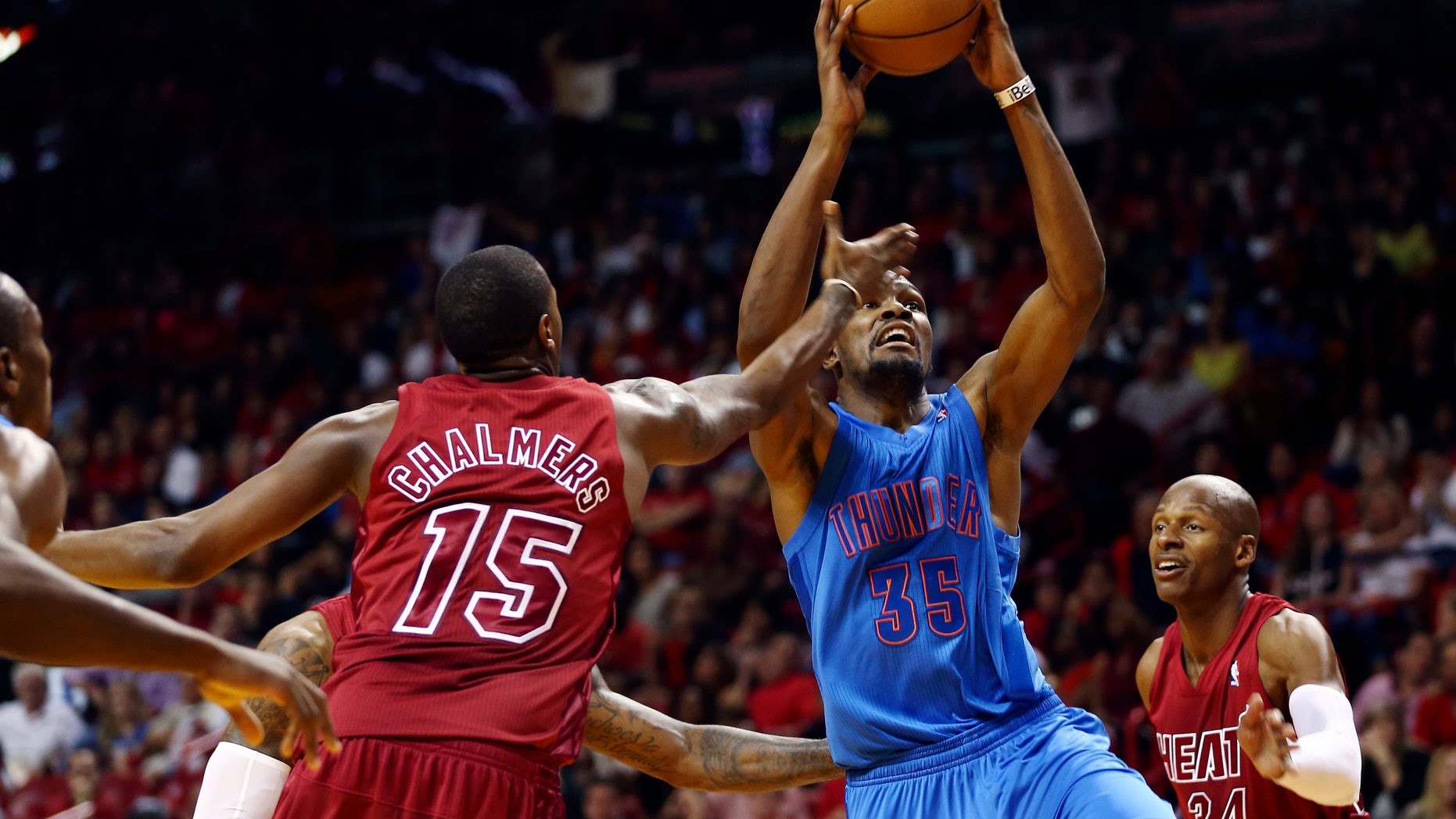 Miami Heat's Mario Chalmers (15) and Ray Allen (34) defend against Oklahoma Cty Thunder's Kevin Durant during the second half of an NBA basketball game in Miami, Tuesday, Dec. 25, 2012. The Heat won 103-97. (AP Photo/J Pat Carter)