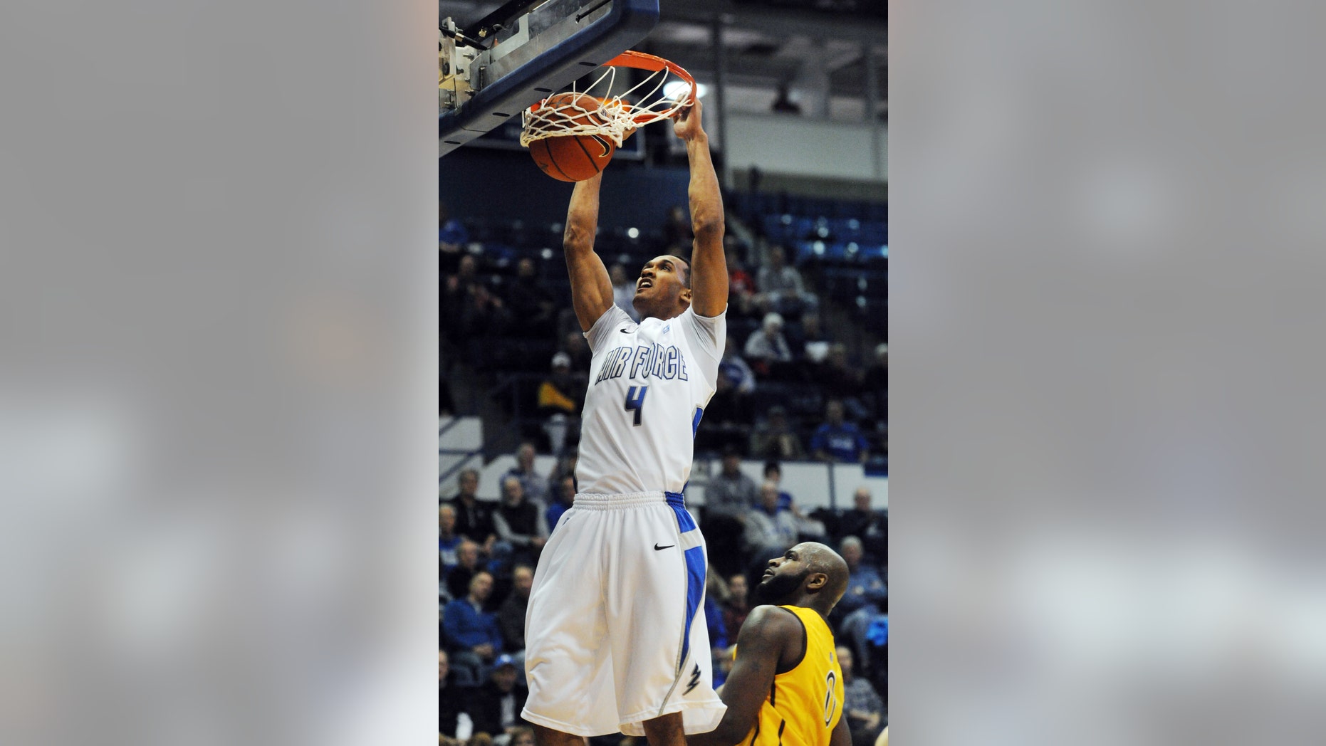 Air Force forward Kamryn Williams (4) dunks over Wyoming forward Leonard Washington during the first half of their NCAA college basketball game, Tuesday, Feb. 26, 2013, at Air Force Academy, Colo. (AP Photo/The Colorado Springs Gazette, Christian Murdock) MAGS OUT