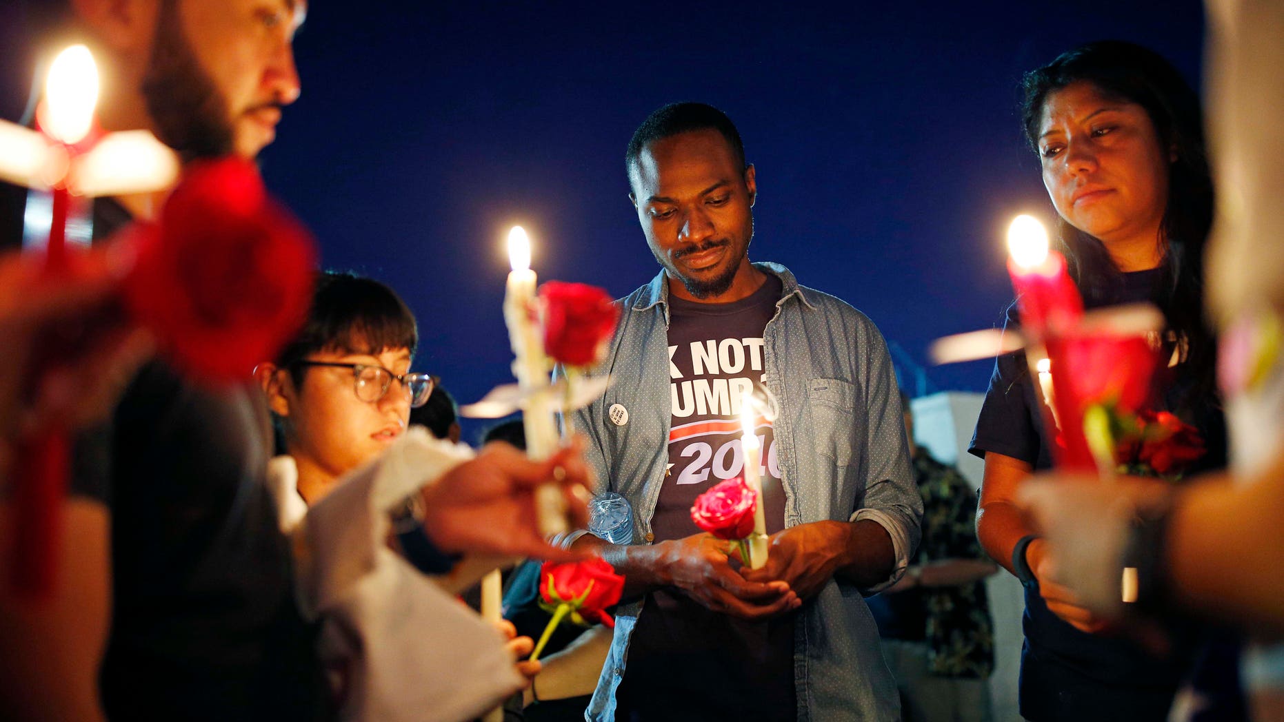 Maurice Forbes, center, holds a candle with others during a vigil at The Center, a community center for the LGBT community, Sunday, June 12, 2016, in Las Vegas. The vigil was for the victims of the Pulse nightclub shooting in Orlando. (AP Photo/John Locher)