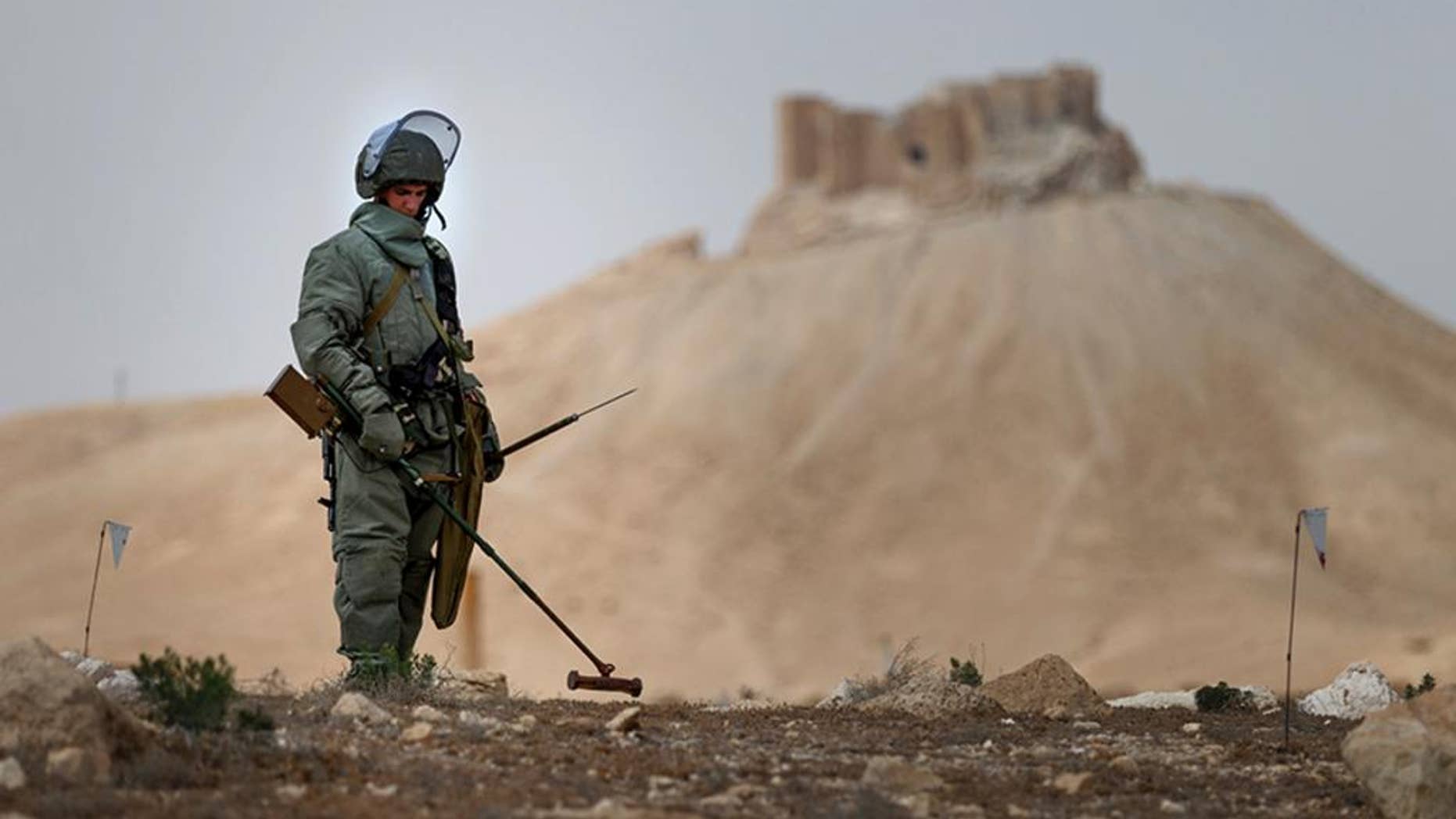 In this photo taken Friday, April 8, 2016 and provided by Russian Defense Ministry press service, a Russian serviceman checks for mines in Palmyra, Syria. Russian combat engineers arrived in Syria on a mission to clear mines in the ancient town of Palmyra, which has been recaptured from Islamic State militants in an offensive that has proven Russia’s military might in Syria despite a drawdown of its warplanes. (Russian Defense Ministry Press Service Photo via AP)