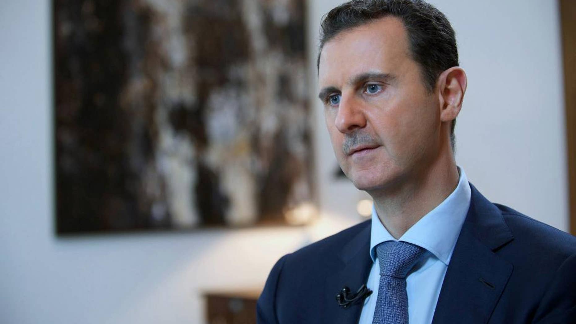 FILE - In this Sunday, Oct. 4, 2015 file photo released by the Syrian official news agency SANA, shows Syrian President Bashar Assad, speaking during an interview with the Iran's Khabar TV, in Damascus, Syria. (SANA via AP, File)