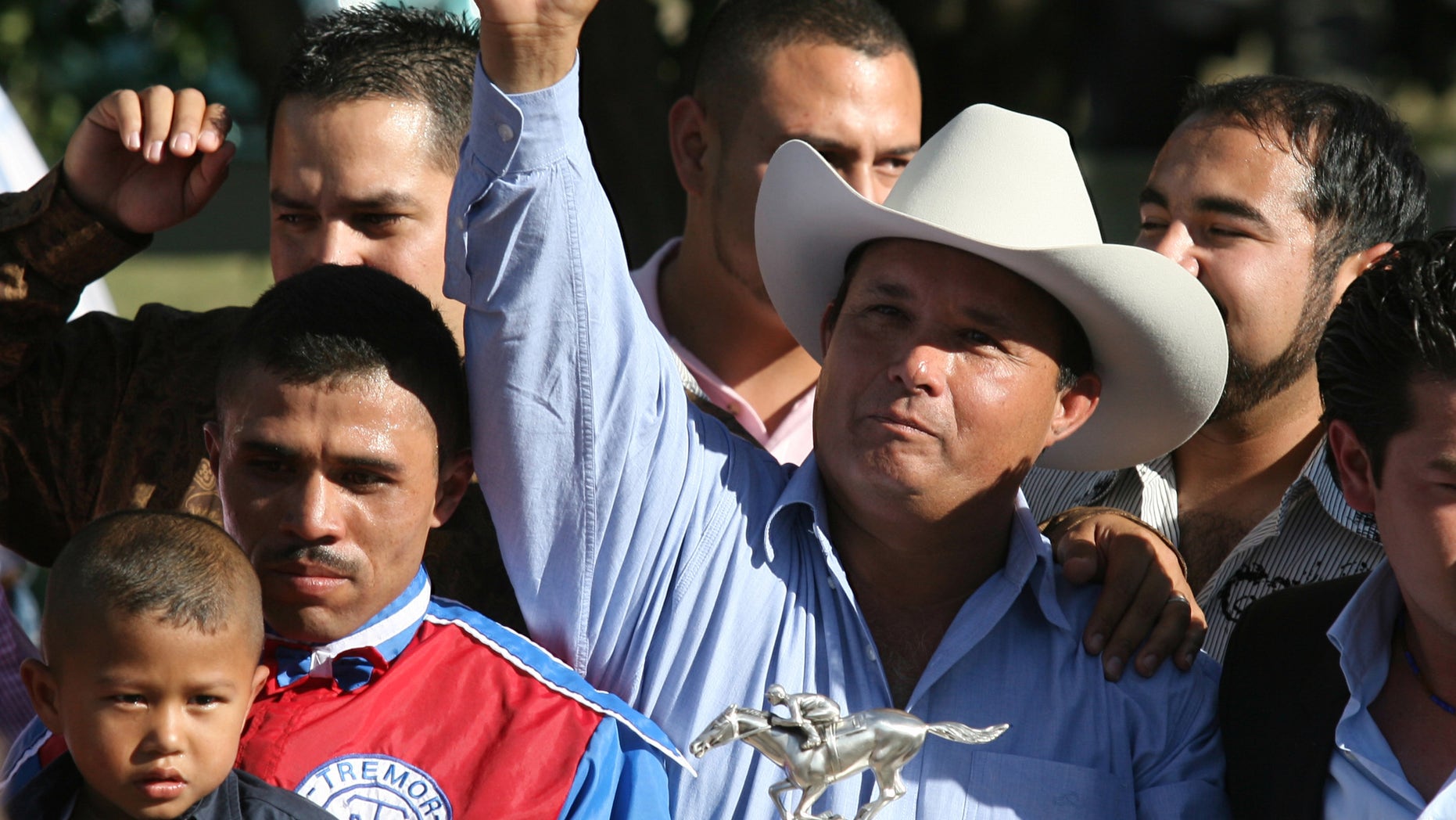 FILE - In this Sept. 6, 2010 file photo, owner Jose Trevino Morales, center, acknowledges the crowd as he stood with the trophy after Mr. Piloto won the All American Futurity horse race at Ruidoso Downs, N.M. Prosecutors told a federal jury on Wednesday, May 8, 2013 that Morales, the man they say is the brother of leaders of Mexico's most blood-soaked criminal organization, used the proceeds from their brothers' ill-gotten gains to bankroll his horse-racing stable. (AP Photo/The El Paso Times, Rudy Gutierrez) EL DIARIO OUT; JUAREZ MEXICO OUT;