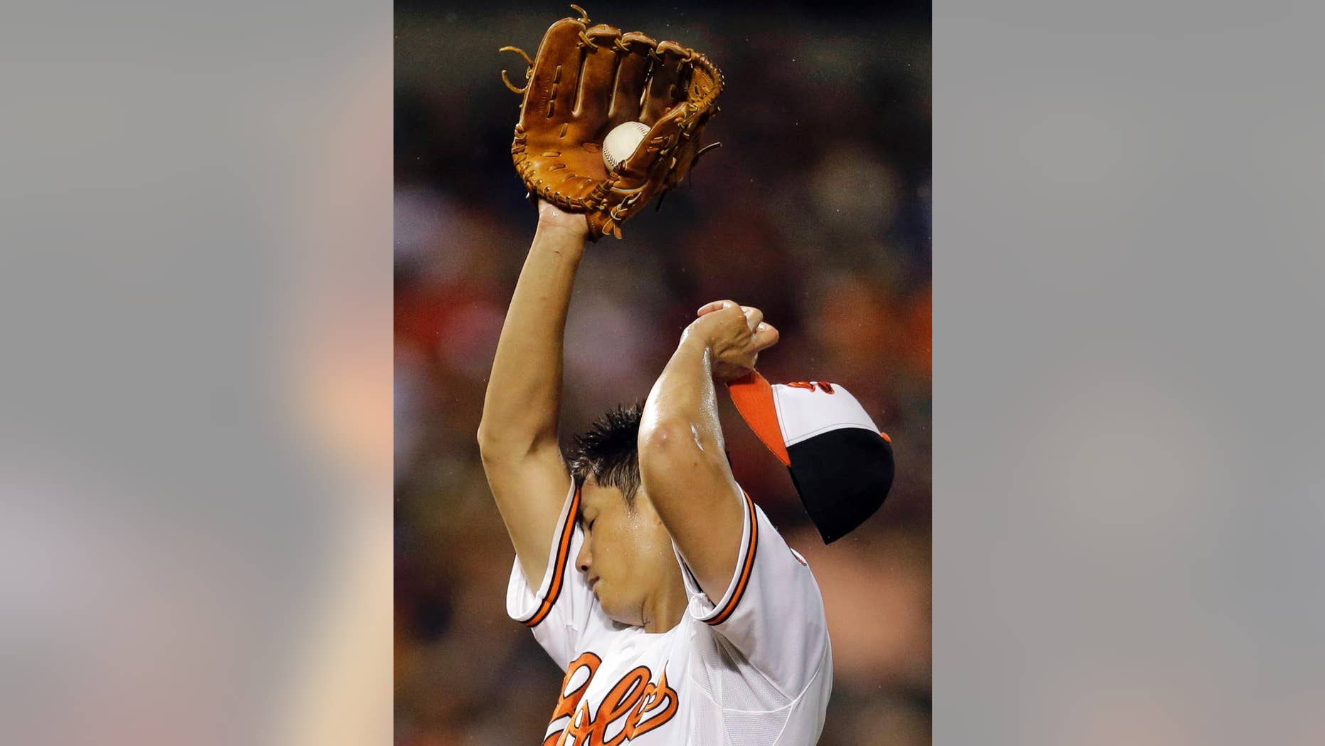 Baltimore Orioles starting pitcher Wei-Yin Chen, of Taiwan, wipes sweat from his face after Washington Nationals' Ryan Zimmerman doubled in the sixth inning of an interleague baseball game, Thursday, July 10, 2014, in Baltimore. Chen was relieved later in the sixth. (AP Photo/Patrick Semansky)