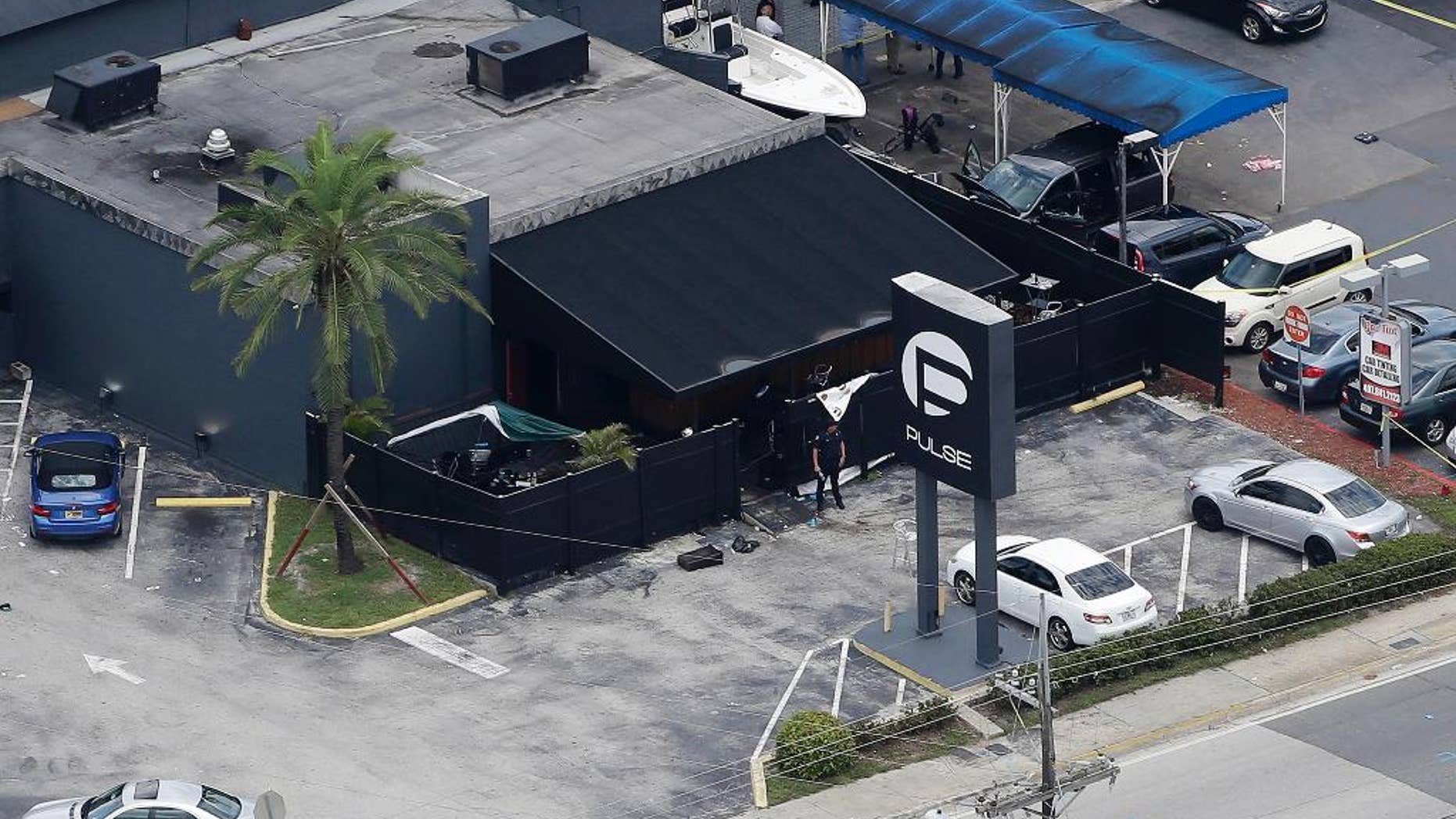 FILE - In this June 12, 2016 file photo, law enforcement officials work at the Pulse nightclub in Orlando, Fla., following a mass shooting. As many as 1,000 potential jurors in the trial of the Orlando nightclub gunman’s wife will have to answer an extensive questionnaire about how much they know about the case. That highlights how complicated it could be to find unbiased jurors in the prosecution of the only case related to the worst mass shooting in modern U.S. history. (AP Photo/Chris O'Meara, File)