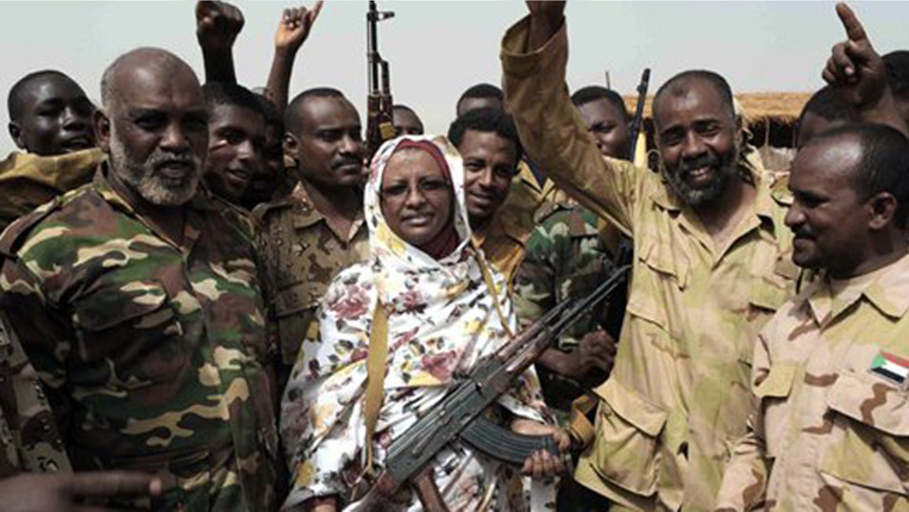 April 24, 2012: Sudanese state Minister of Information Sana Hamad poses for a photo with Sudanese armed forces at the oil-rich border town of Heglig, Sudan.