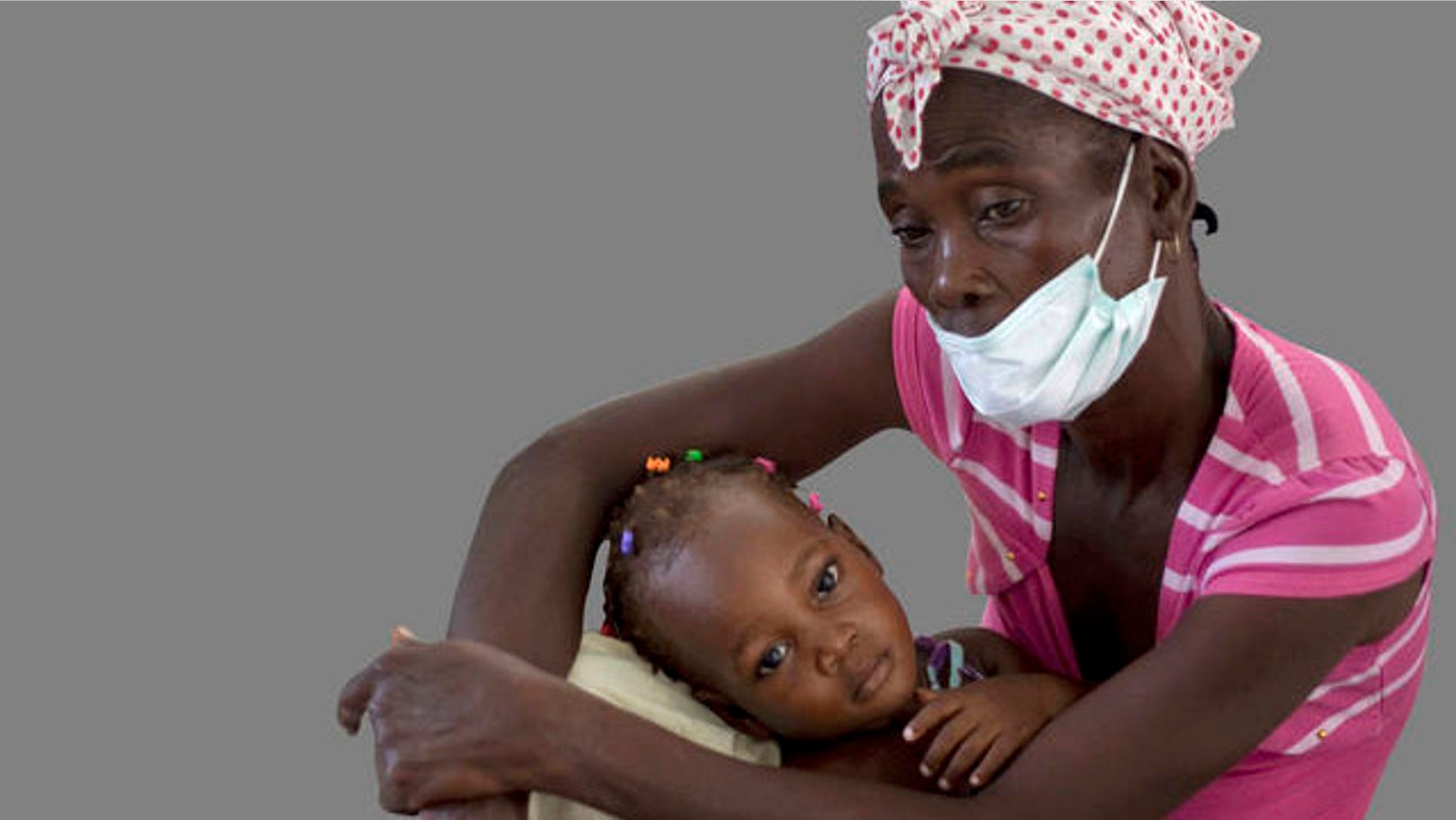 A woman holds her young daughter wile receiving medical attention at St. Nicholas hospital in Saint Marc, Haiti, Friday, Oct. 22, 2010. An outbreak of cholera in rural central Haiti has killed at least 142 people and sickened hundreds more who overwhelmed the hospital in Saint Marc seeking treatment. (AP Photo/Ramon Espinosa)