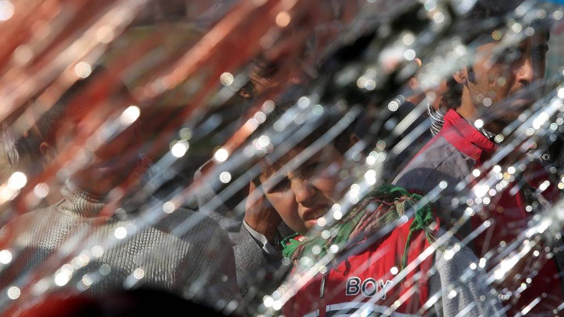 Afghans look at a broken windshield of a civilian vehicle damaged by a roadside bomb, in Kabul, Afghanistan, Tuesday, Oct. 14, 2014. The Afghan interior ministry said that several Afghan civilians have been killed in the bomb blast in the western part of the country’s capital. (AP Photo/Massoud Hossaini)