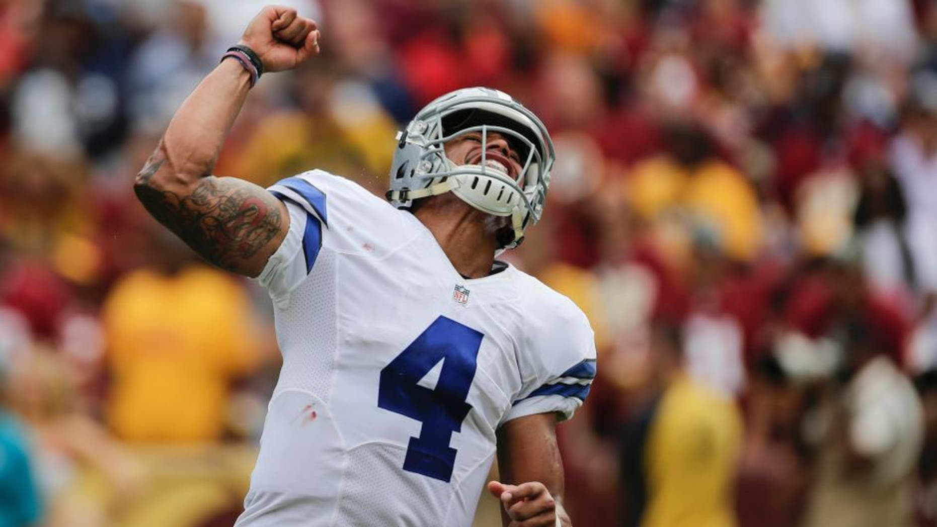 Dallas Cowboys quarterback Dak Prescott (4) celebrates linebacker Albert Morris's touchdown during the second half of an NFL football game against the Washington Redskins in Landover, Md., Sunday, Sept. 18, 2016. The Cowboys defeated the Redskins 27-23. (AP Photo/Mark Tenally)
