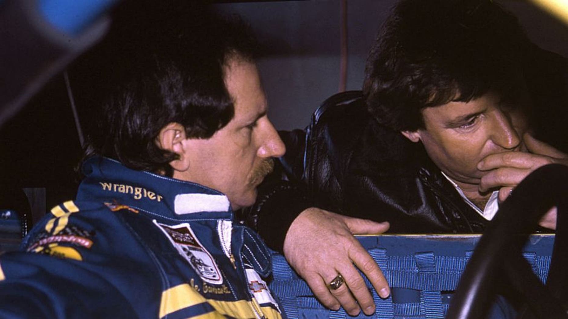 Driver Dale Earnhardt (L) and car owner Richard Childress are deep in conversation at a NASCAR Cup race, circa 1985. Earnhardt brought the Wrangler sponsorship to Childress racing in 1984 and began a relationship that lasted until 2001, earning the team six Cup championships. (Photo by ISC Images & Archives via Getty Images)