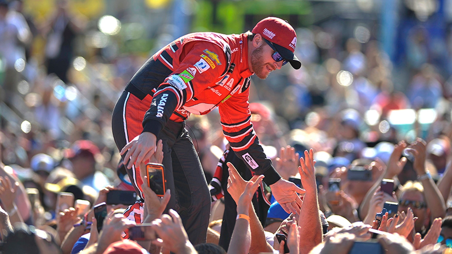 Dale Earnhardt Jr. greets fans as he is introduced before a NASCAR Cup Series auto race at Homestead-Miami Speedway in Homestead, Fla., Sunday, Nov. 19, 2017. (AP Photo/Gaston De Cardenas)