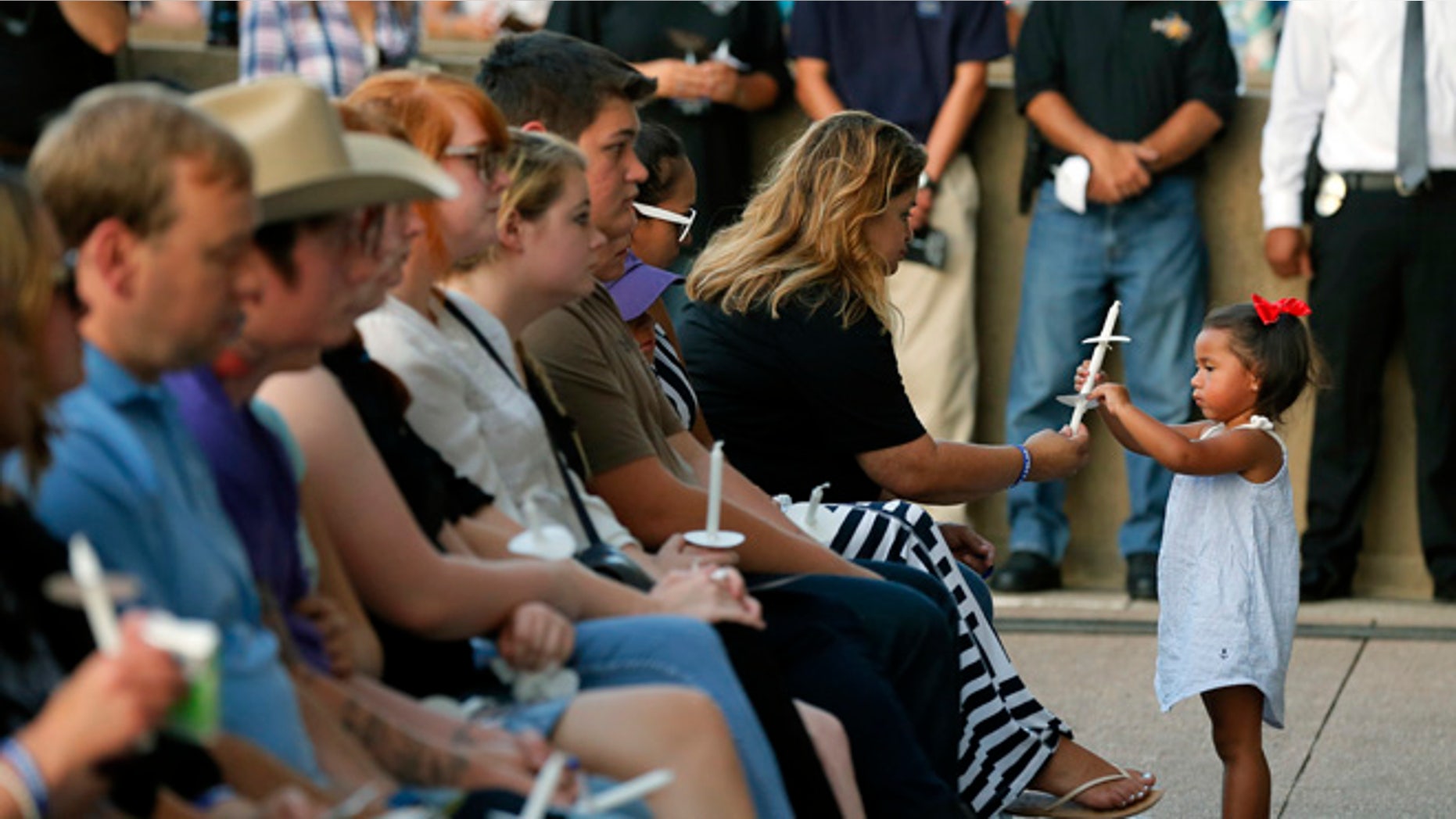 Family and friends of fallen police officers take part in a candlelight vigil at City Hall on Monday, July 11, 2016, in Dallas. Five police officers were killed and several injured during a shooting in downtown Dallas last Thursday night. (AP Photo/Tony Gutierrez)