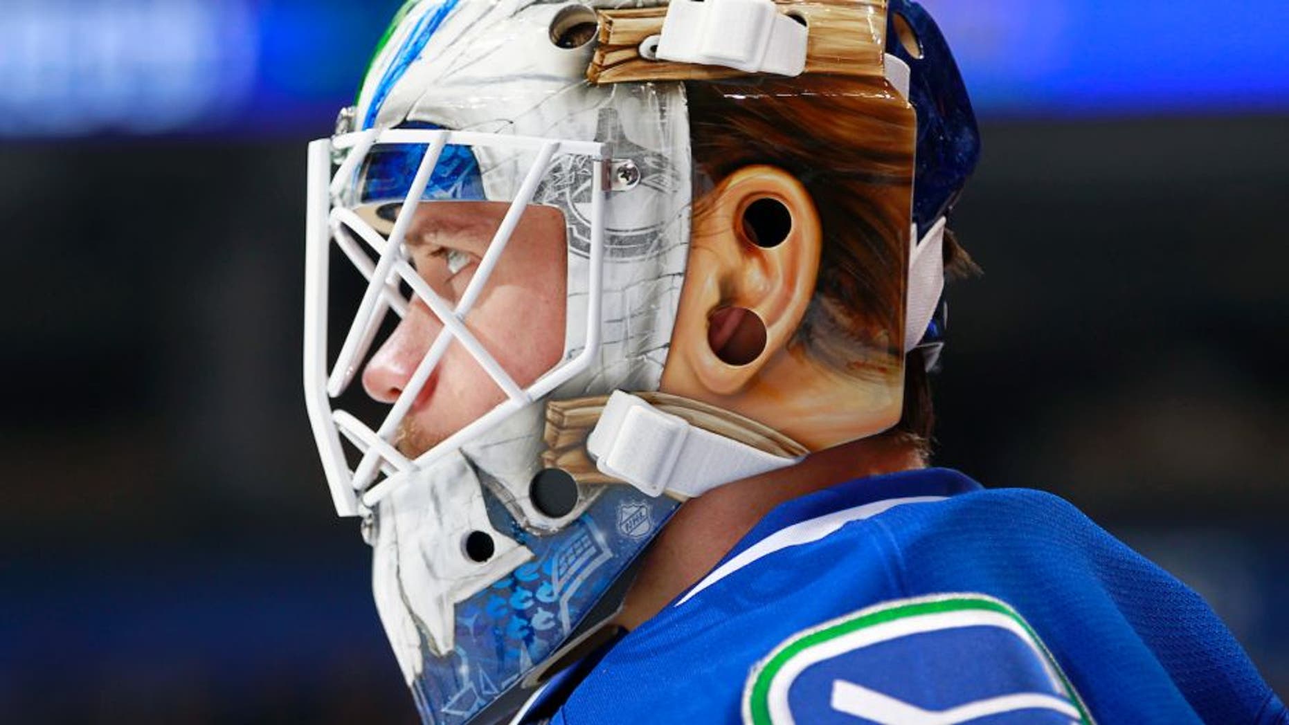 VANCOUVER, BC - NOVEMBER 13: Jacob Markstrom #25 of the Vancouver Canucks dons a new mask during warmup before their NHL game against the Dallas Stars at Rogers Arena November 13, 2016 in Vancouver, British Columbia, Canada. (Photo by Jeff Vinnick/NHLI via Getty Images)