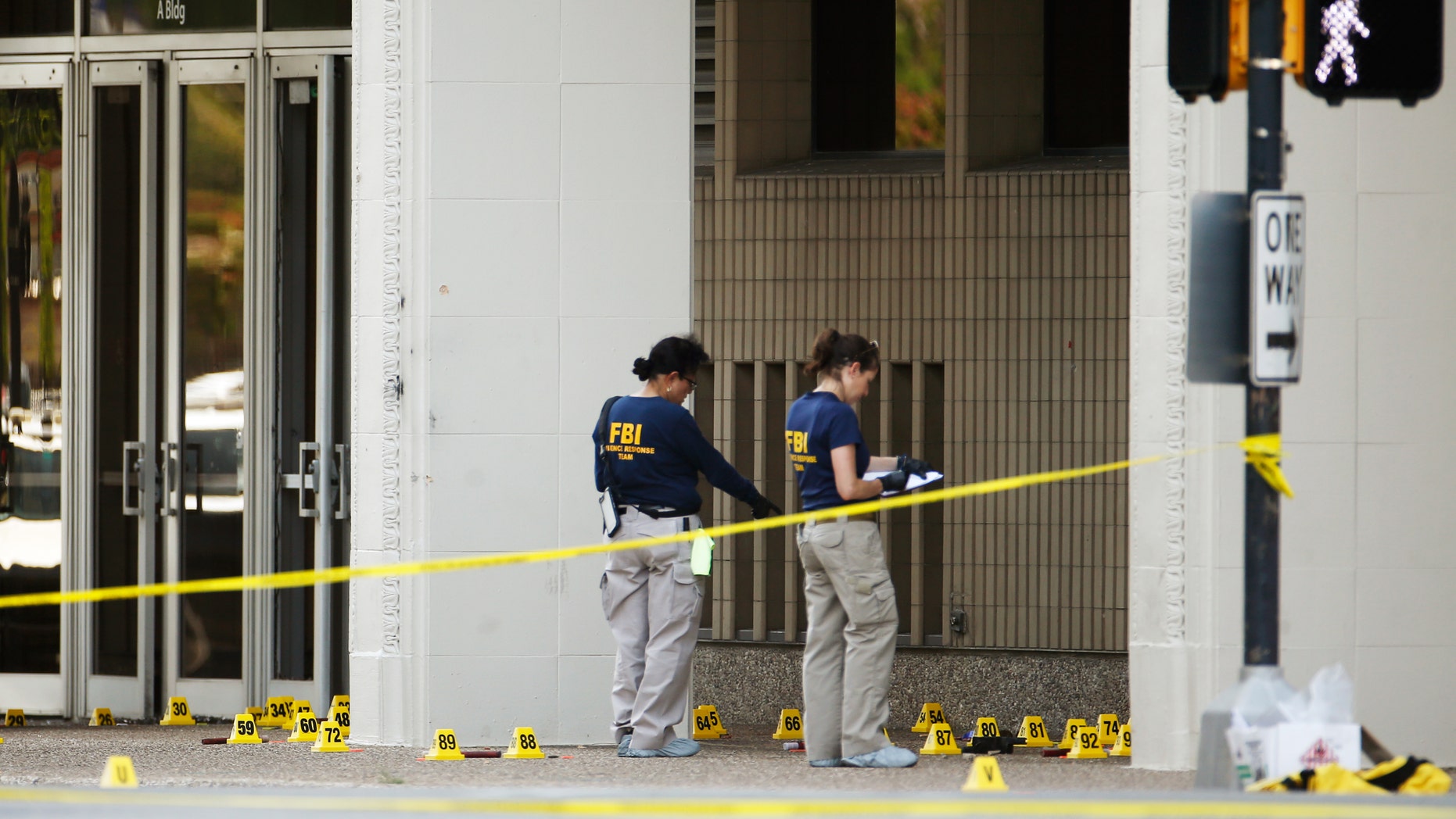 FBI investigators look over the crime scene in Dallas, Texas, U.S. July 8, 2016 following a Thursday night shooting incident that killed five police officers. (REUTERS/Carlo Allegri)