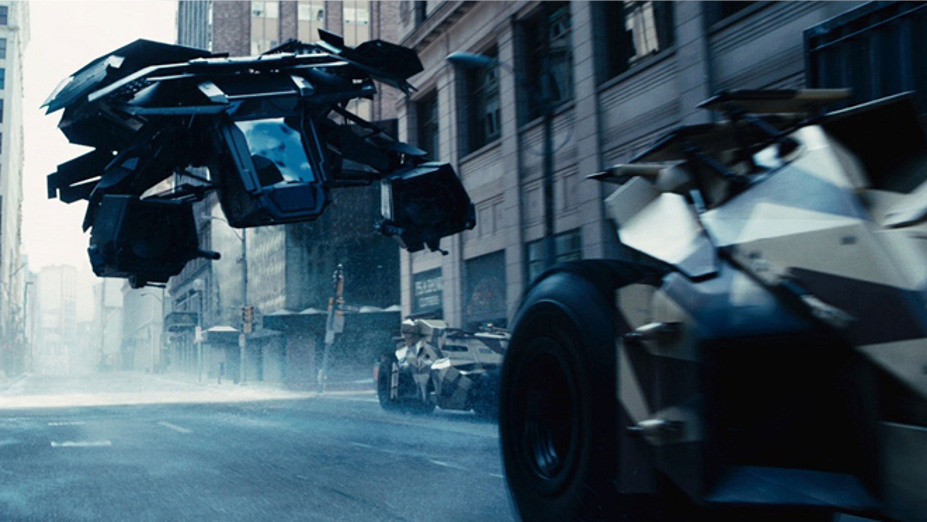 The Bat flying vehicle flies through Gotham's urban canyons in the Dark Knight Rises.