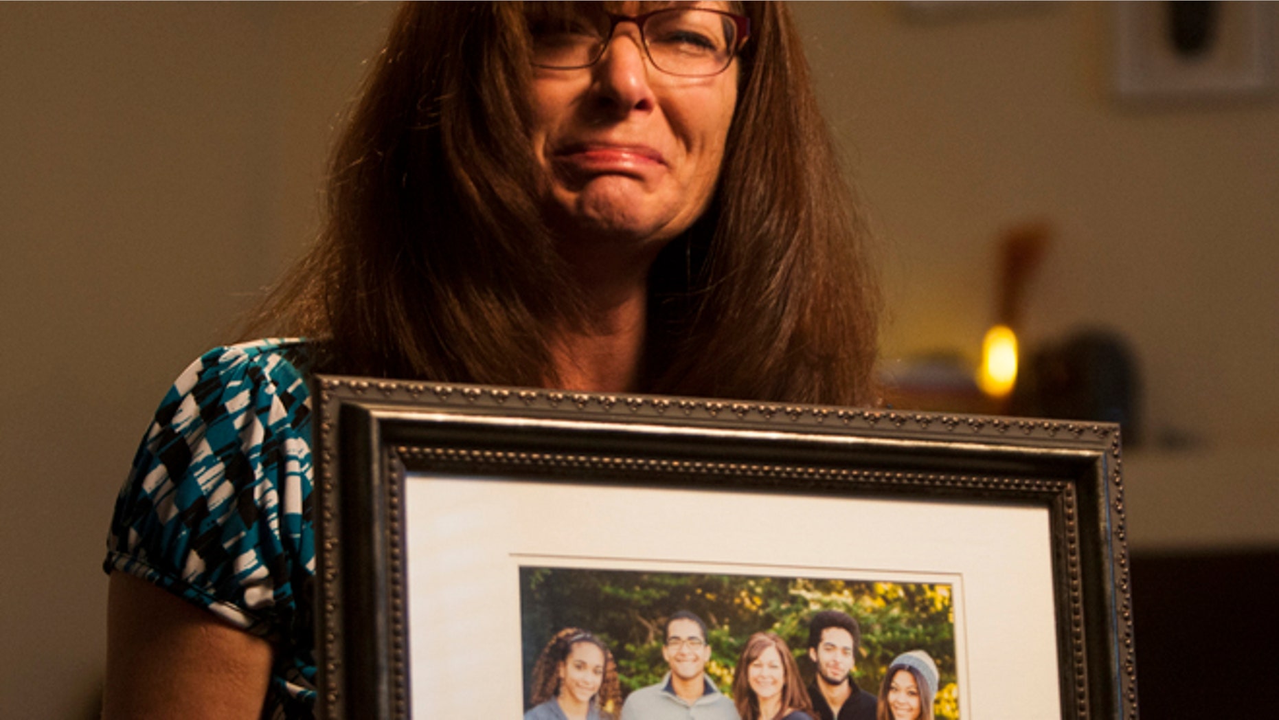 Sept. 12, 2014: Susan Hunt holds a photo of her family, including her son, Darrien Hunt, at her home in Saratoga Springs, Utah.