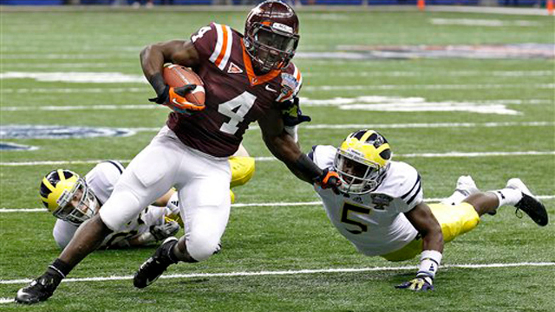 Jan. 3, 2012: Virginia Tech running back David Wilson (4) tries to turn the corner past Michigan cornerback Courtney Avery (5) and safety Jordan Kovacs during the first quarter of the Sugar Bowl NCAA college football game in New Orleans.
