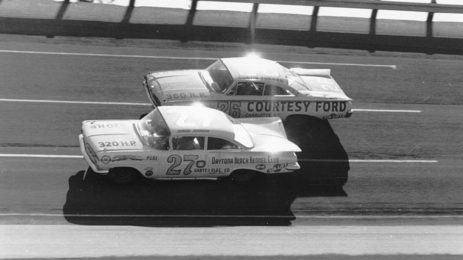 DAYTONA BEACH, FL - FEBRUARY 14: Eventual winner of the 1960 Daytona 500, Junior Johnson #27 ducks beneath Curtis Turner #26 who finished 7th during the Daytona 500 on February 14, 1960 at the Daytona International Speedway in Daytona Beach, Florida. There were so many wrecked and disabled cars following this event that NASCAR canceled the next two scheduled meets for fear of lack of participants. (Photo by ISC Archives via Getty Images)