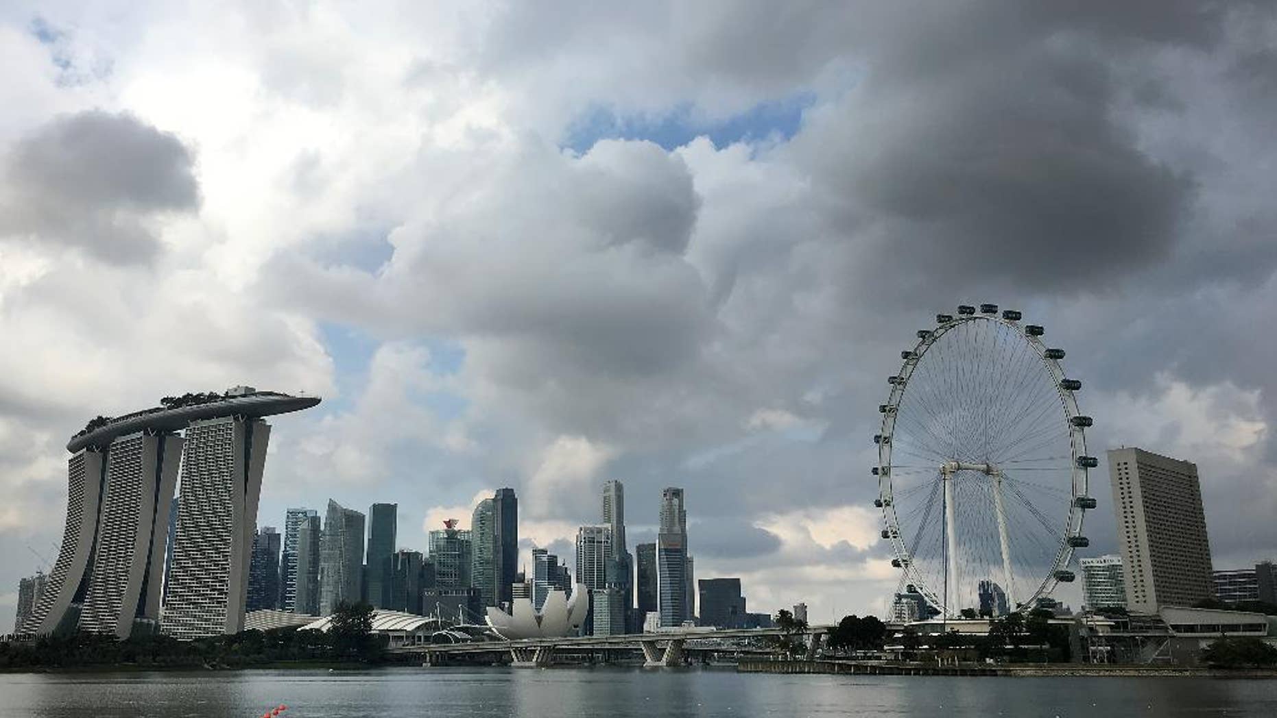 FILE - In this Wednesday, April 20, 2016, file photo, two kayaks are dwarfed against the skyline of the Marina Bay area, which is home to popular hotels, and tourist attractions such as the Singapore Flyer, the city-state's observation wheel seen at right, in Singapore. Indonesia's counter-terrorism police on Friday arrested six suspected militants who were allegedly planning to launch a rocket attack on Singapore's downtown from nearby Batam island. (AP Photo/Wong Maye-E, File)