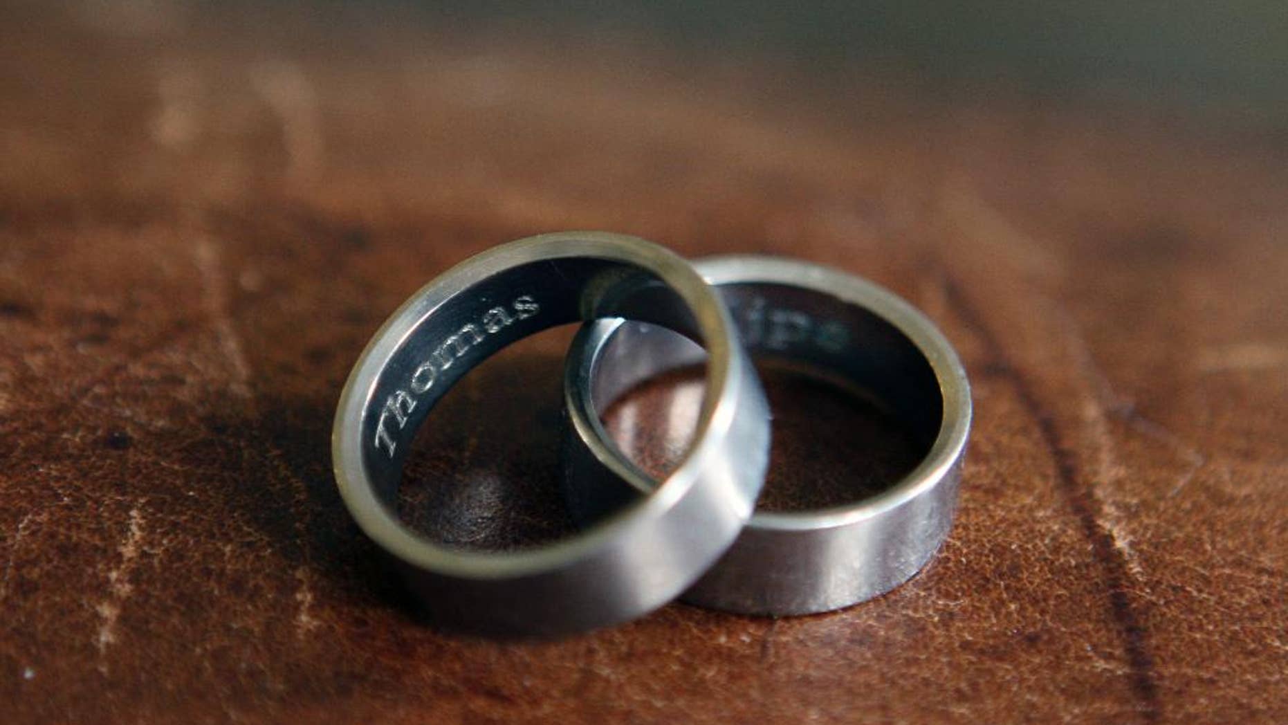In this photo taken March 22, 2015, the rings of Thomas Kostura and Ijpe DeKoe sit on a table in their Memphis, Tenn. apartment. According to an Associated Press-GfK poll in April, nearly half of Americans favor laws allowing gay and lesbian couples to wed in their own states, while just over a third are opposed. The poll was conducted just before the Supreme Court heard oral arguments in a case that will probably decide whether states can continue to bar same-sex couples from marrying. Kostura and deKoe were married in New York in 2011. (AP Photo/Karen Pulfer Focht)