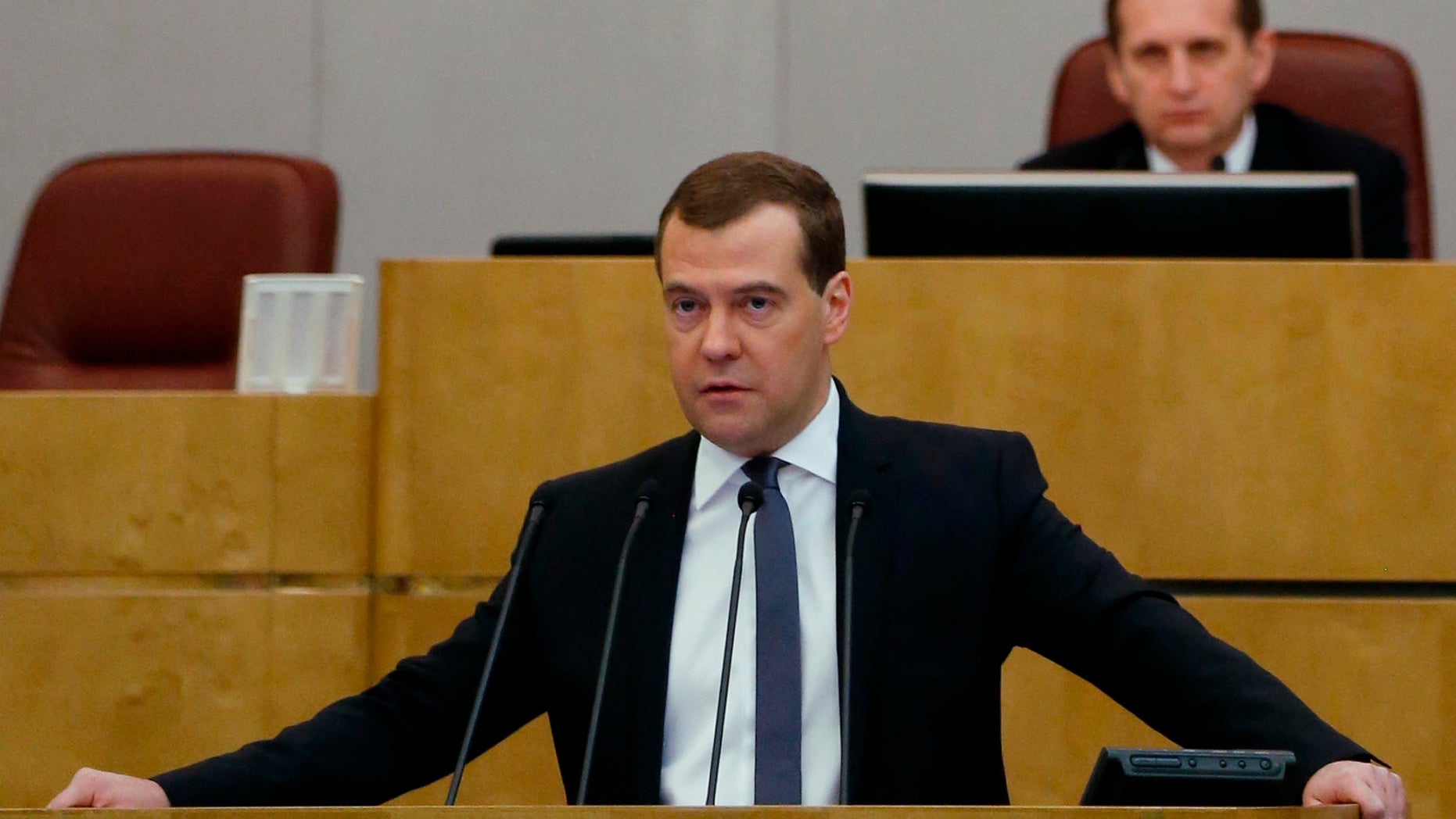 Russian Prime Minister Dmitry Medvedev addresses the State Duma, lower parliament chamber, during an annual report in Moscow on Wednesday, April 17, 2013. Parliament speaker Sergei Naryshkin listens at the background.(AP Photo/RIA Novosti, Dmitry Astakhov, Government Press Service)