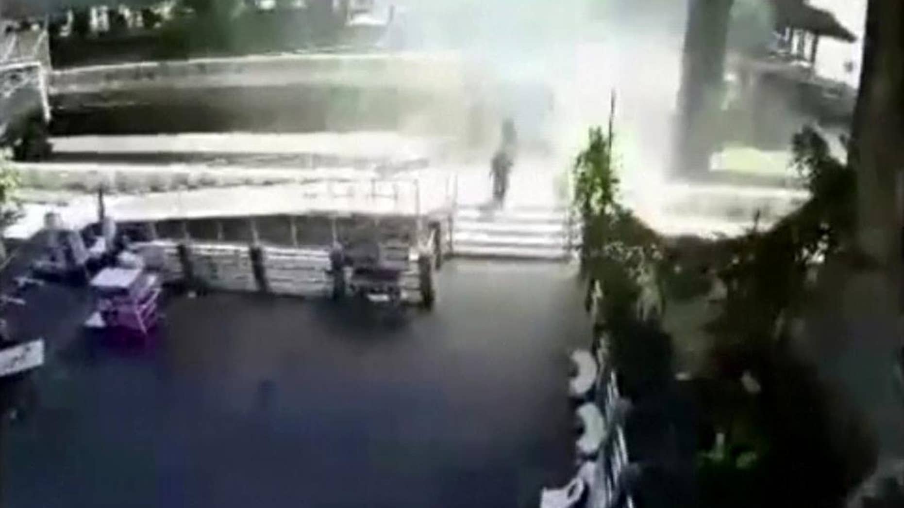FILE - In this Tuesday, Aug. 18, 2015, photo, people run from an explosion at a ferry pier in Bangkok, Thailand. No one was hurt in Tuesday's blast, but police say the explosive device was thrown from a bridge and blew up after falling into the river below. A Thai court on Thursday, Aug. 27, 2015, issued an arrest warrant for an unnamed suspect in the riverside blast. (Photo via AP)