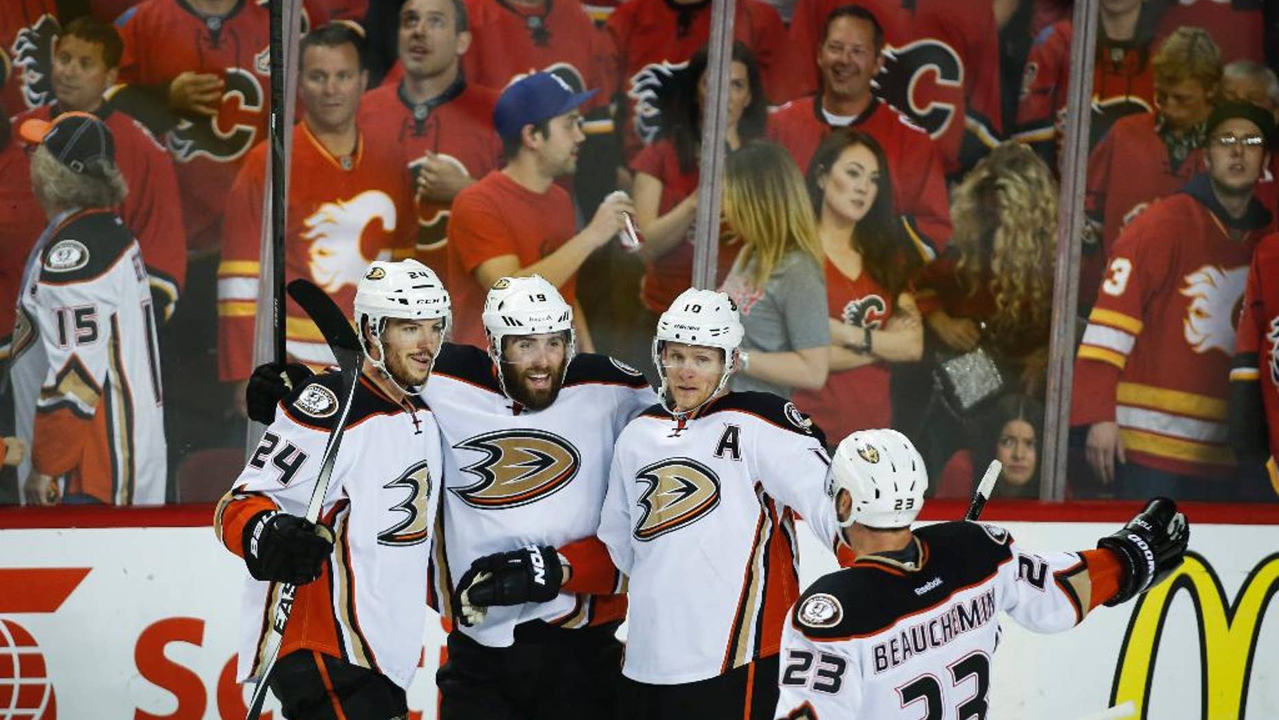 Anaheim Ducks' Simon Despres, from left, Patrick Maroon, Corey Perry and Francois Beauchemin celebrate their 4-2 win during the third period of Game 4 in an NHL hockey second-round playoff series against the Calgary Flames, Friday, May 8, 2015, in Calgary, Alberta. (Jeff McIntosh/The Canadian Press via AP) MANDATORY CREDIT