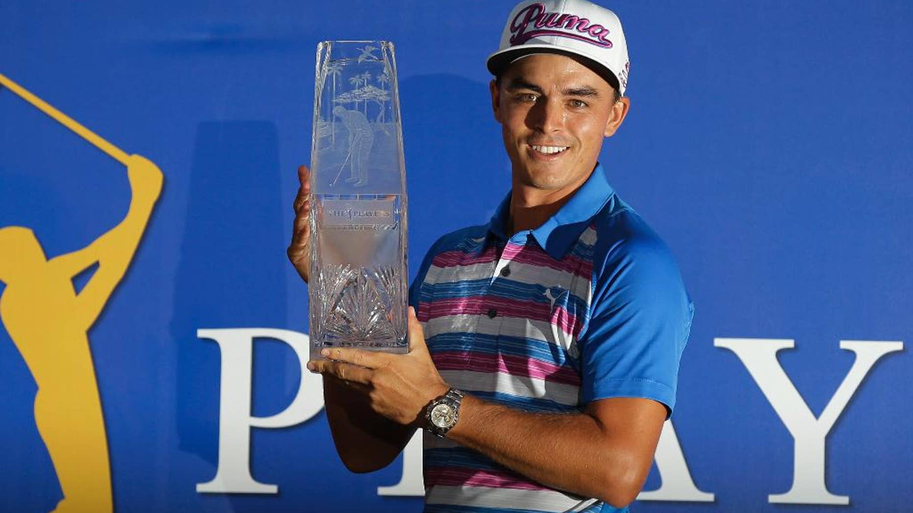 Rickie Fowler holds The Players Championship trophy, Sunday, May 10, 2015, in Ponte Vedra Beach, Fla. Fowler won in a sudden death playoff against Kevin Kisner. (AP Photo/Chris O'Meara)