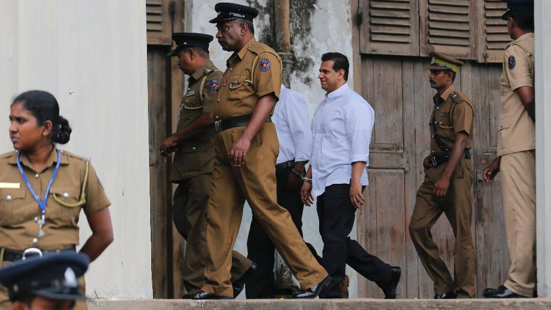 Sri Lankan police and prison officers escort former lawmaker Duminda Silva after he was sentenced to death, at a court complex in Colombo, Sri Lanka, Thursday, Sept. 8, 2016. A Sri Lankan court has sentenced Silva to death over the killing of a rival politician Bharatha Lakshman Premachandra in an election-related attack five years ago. Silva is likely to serve a life sentence because Sri Lanka has a moratorium on death penalty. (AP Photo/Eranga Jayawardena)