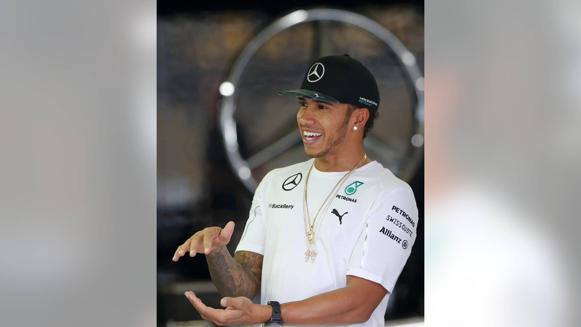 Mercedes driver Lewis Hamilton, of Britain, laughs in his team's pit at the Interlagos race track in Sao Paulo, Brazil, Thursday, Nov. 6, 2014. The Formula One Brazilian Grand Prix will take place on Nov. 9. (AP Photo/Andre Penner)