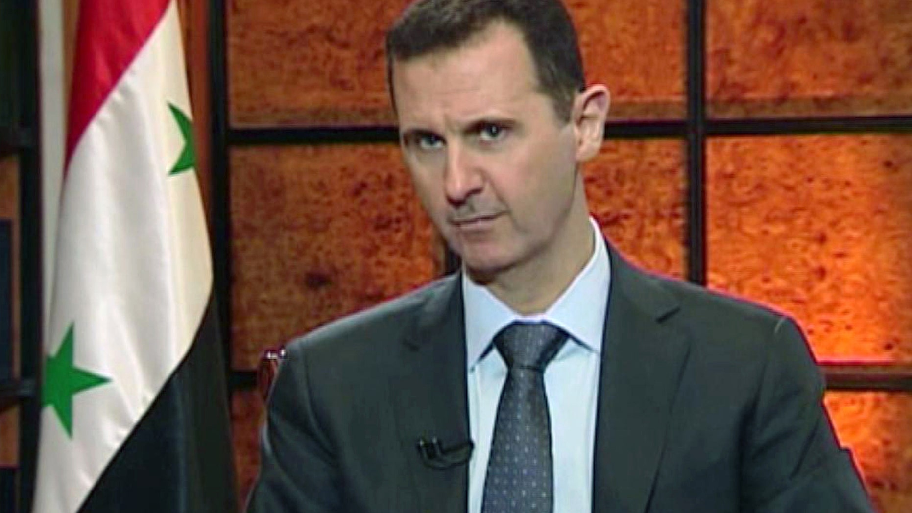 FILE - In this file image from video broadcast on Syrian state television Wednesday, April 17, 2013, President Bashar Assad speaks during an interview. The Syrian government wants more details before deciding whether to take part in a proposed U.S.-Russian initiative to negotiate a peaceful end to Syria's crisis, the country's information minister said Tuesday, May 14, 2013, staking out a similar position to the main opposition group. One of the key sticking points in even bringing the sides to the table for talks has been the role of Assad in any negotiated transition.(AP Photo/Syrian State TV via AP video, File)