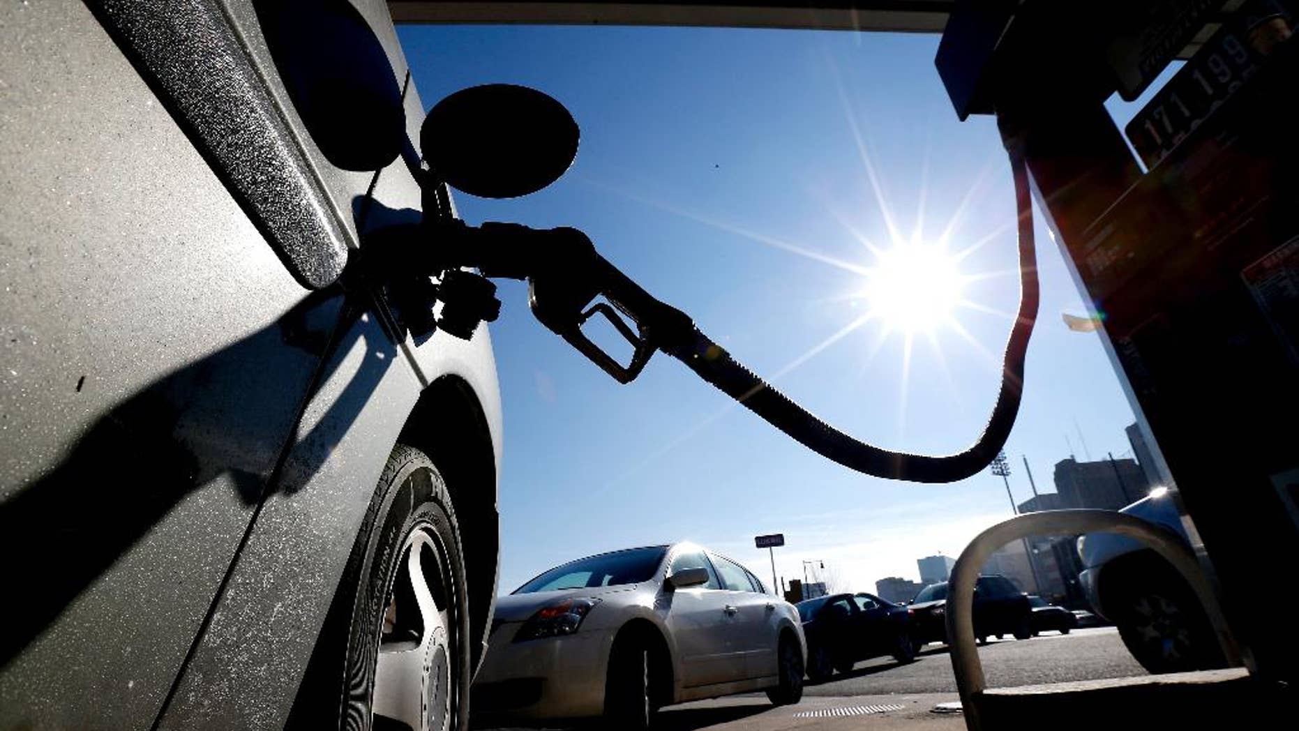 FILE - In this Friday, Jan. 23, 2015, file photo, vehicles form a line behind a motorist gassing up at a gas station in Newark, N.J. The Commerce Department releases its February report on consumer spending, which accounts for 70 percent of economic activity, on Monday, March 30, 2015. (AP Photo/Julio Cortez, File)