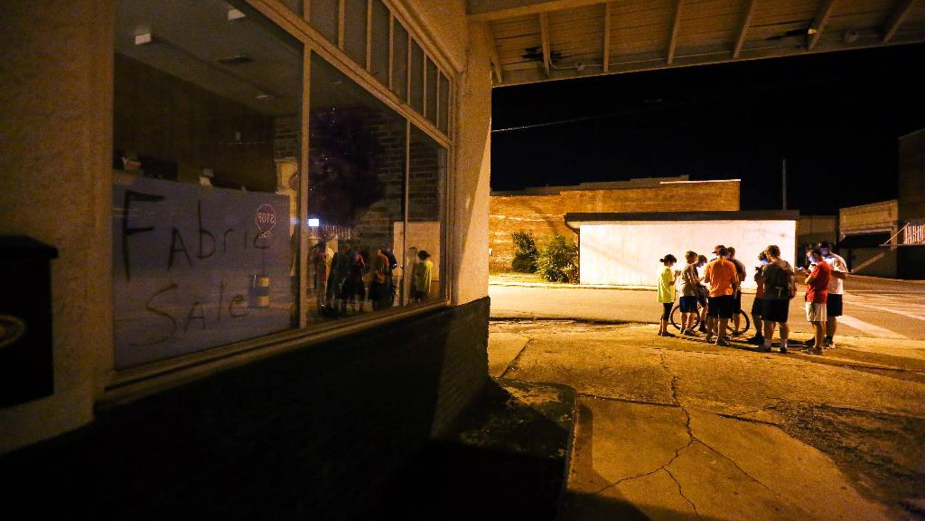 A group of teenagers play "Pokemon Go" in downtown Hartselle, Ala., on Wednesday, July 13, 2016. (Crystal VanderWeit/The Decatur Daily via AP)