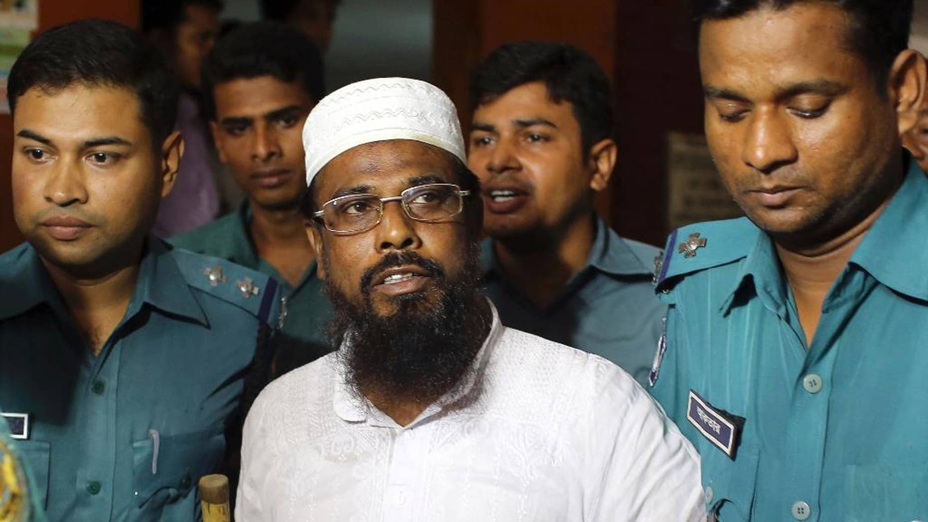 FILE - In this June 16, 2014 file photo, Mufti Abdul Hannan, center, leader of banned radical group Harkatul Jihad al Islami, stands at a court in Dhaka, Bangladesh. Authorities in Bangladesh have executed Hannan and two accomplices for their involvement in a grenade attack against a British diplomat at a popular Islamic shrine in 2004. (AP Photo/A.M. Ahad, File)