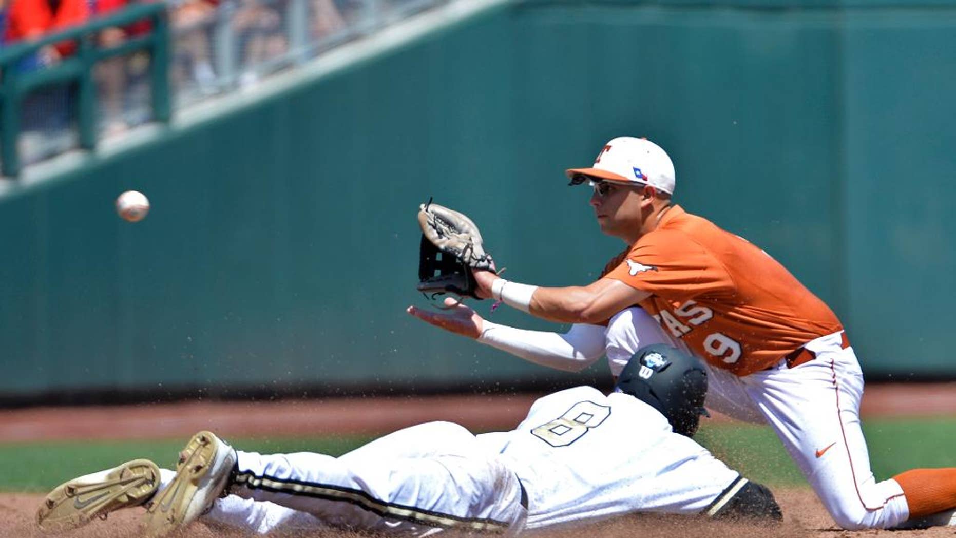 Vanderbilt's Rhett Wiseman (8) is caught stealing second base as Texas shortstop C.J Hinojosa (9) fields the throw in time during the second inning of an NCAA College World Series baseball game in Omaha, Neb., Friday, June 20, 2014. (AP Photo/Ted Kirk)