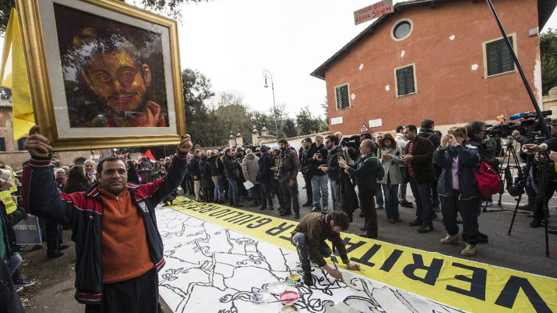FILE - In this Feb. 25, 2016 file photo, a man holds up a portrait of Giulio Regeni, the Italian student slained in Cairo, as several dozen people stage a sit-in outside Egypt's embassy in Rome. Egypt’s chief prosecutor has told Italian authorities Cairo police investigated an Italian researcher weeks before the young man was found tortured to death in the Egyptian capital, according to a statement Friday, Sept. 9, 2016 from both sides. (Massimo Percossi/ANSA via AP, File)