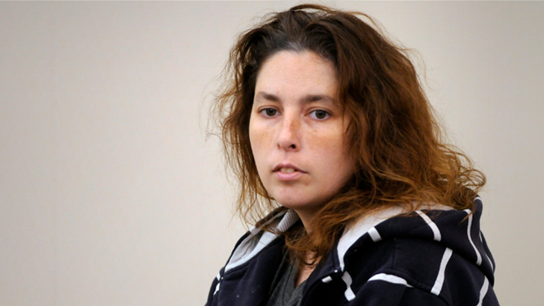 FILE - In this Friday, Sept. 12, 2014, file photo, Erika Murray enters the courtroom by a court officer for her arraignment at Uxbridge District Court in Uxbridge, Mass. Murray was arraigned in September 2014 on charges of fetal death concealment, witness intimidation and permitting substantial injury to a child. Murray is scheduled to appear in court, Tuesday, Oct. 14, 2014, for a status hearing. (AP Photo/Worcester Telegram & Gazette, Paul Kapteyn, Pool, File)