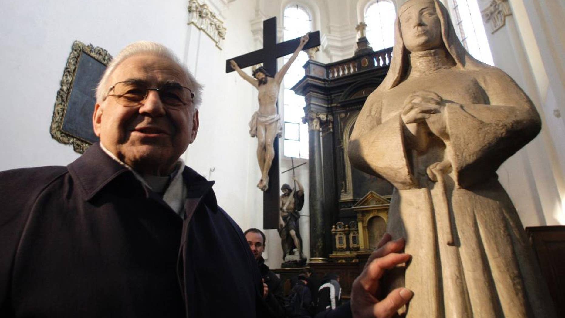 FILE - In this Tuesday, Feb. 16, 2010 file photo, Cardinal Miloslav Vlk poses by a statue of St. Agnes as archeologists start to work on removing stones under an altar in the church of St. Castalus, in Prague, Czech Republic. Prague Cardinal Miloslav Vlk, who ministered clandestinely to Catholics for years while officially working as a window-washer during communist rule in Czechoslovakia, has died at age 84, it was announced on Saturday, March 18, 2017. (AP Photo/Petr David Josek, File)