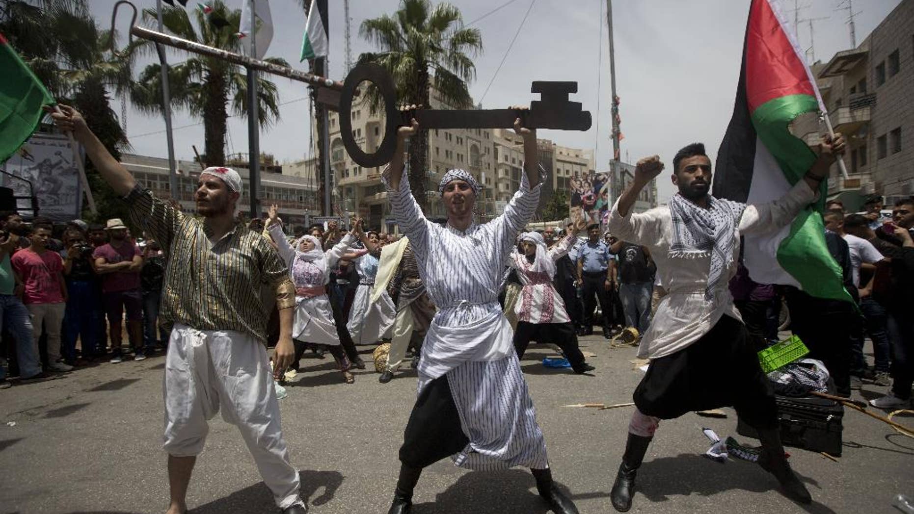Palestinians act in a play enacting "Nakba" or Catastrophe day in the West Bank city of Ramallah, Sunday, May 15, 2016. Palestinians marked the 68th anniversary of their displacement following the Israeli declaration of independence in 1968. (AP Photo/Majdi Mohammed)