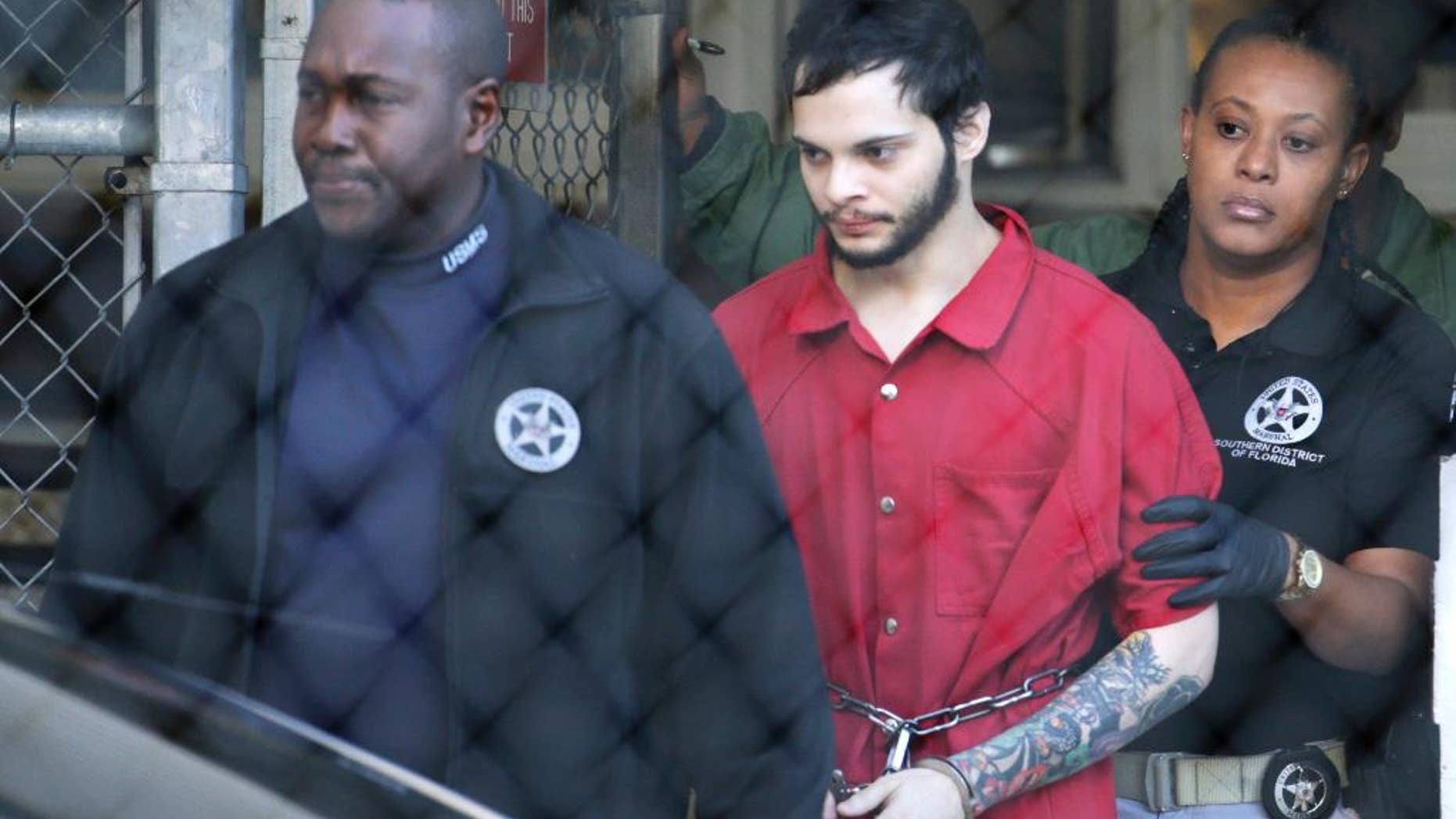 Esteban Santiago, center, is led from the Broward County jail for an arraignment in federal court, Monday, Jan. 30, 2017, in Fort Lauderdale, Fla.
