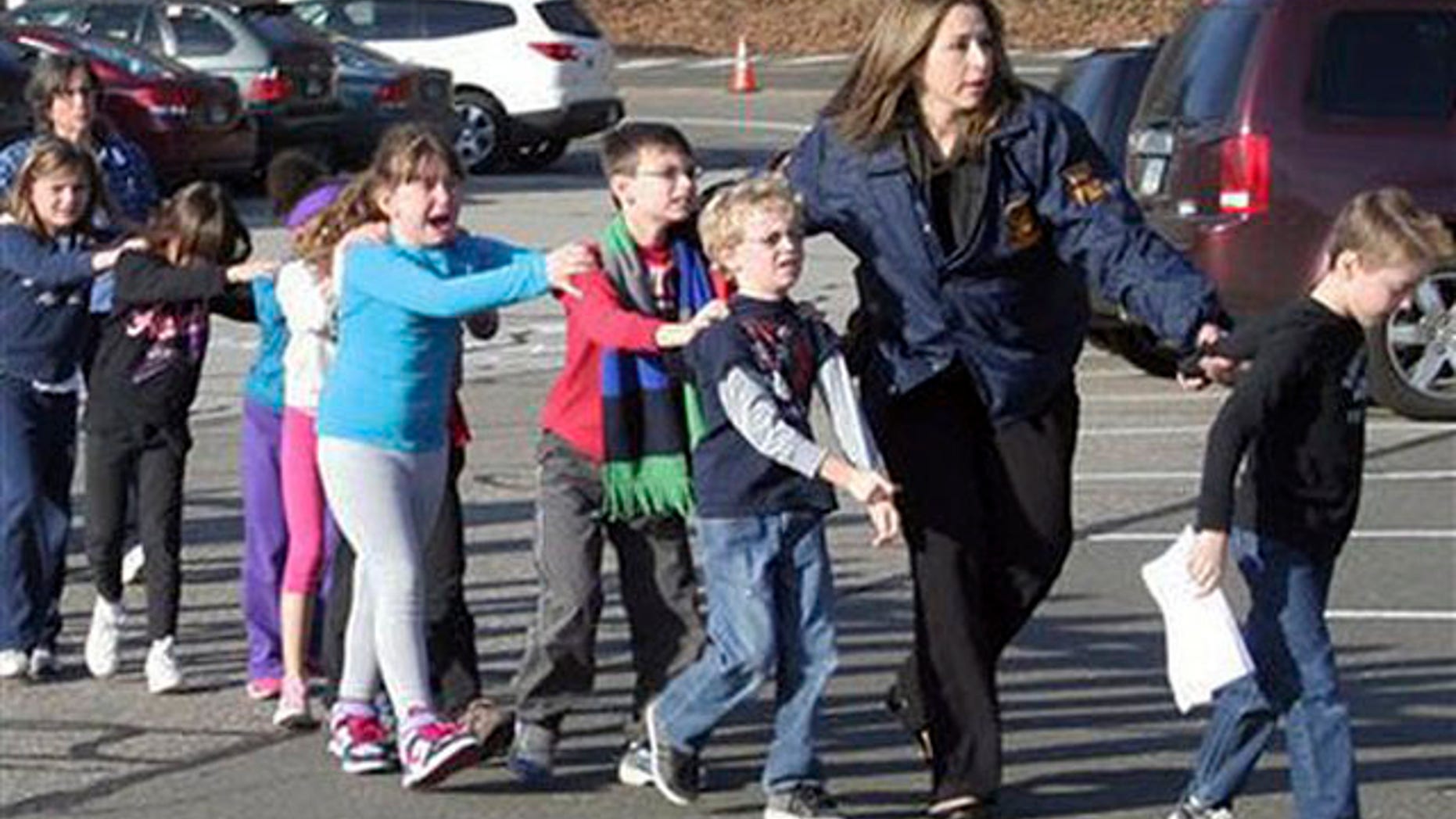In this photo provided by the Newtown Bee, Connecticut State Police lead children from the Sandy Hook Elementary School in Newtown, Conn., following a reported shooting there Friday, Dec. 14, 2012.