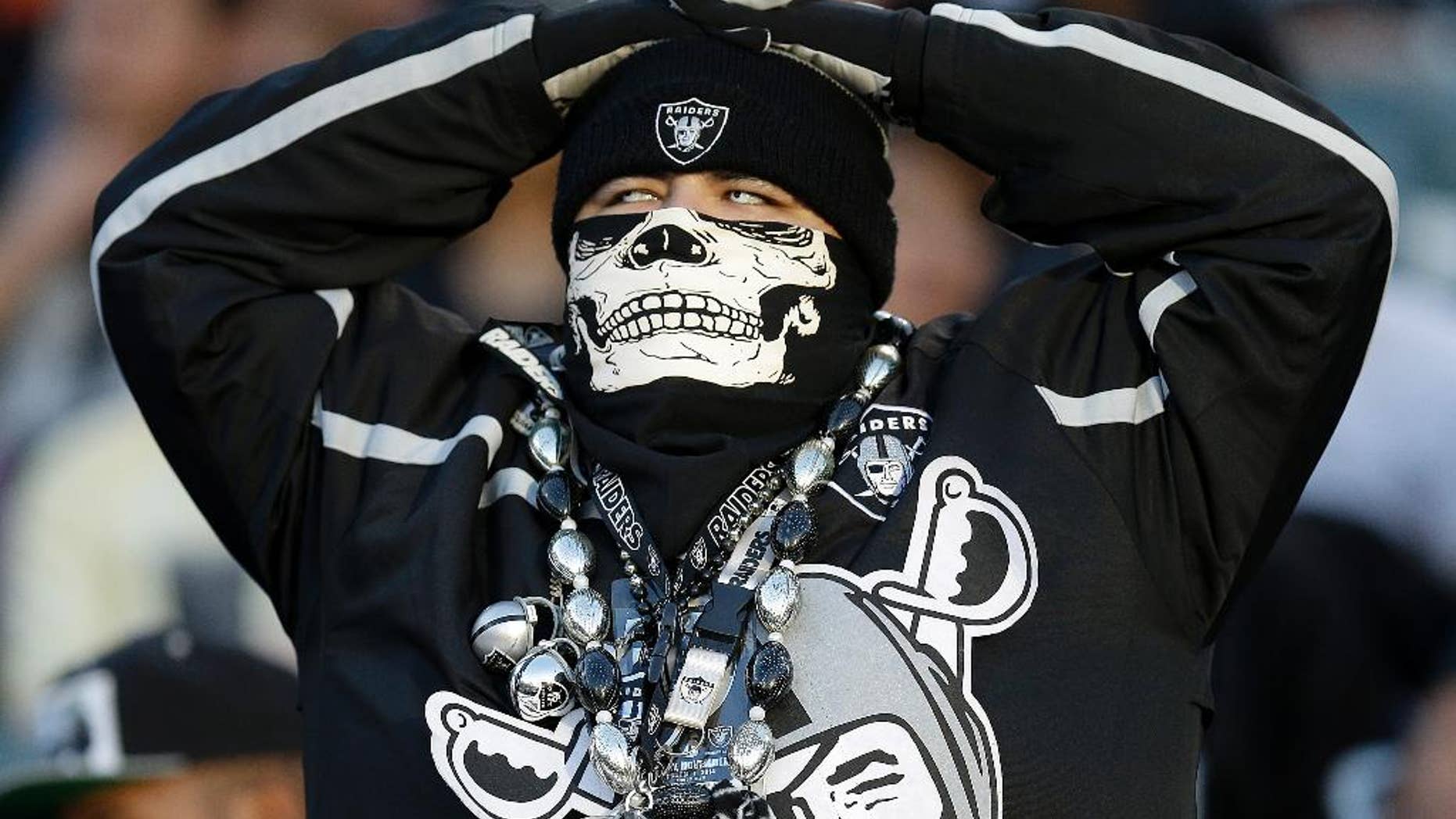An Oakland Raiders fan watches from his seat during the fourth quarter of an NFL football game between the Raiders and the Denver Broncos in Oakland, Calif., Sunday, Nov. 9, 2014. (AP Photo/Ben Margot)